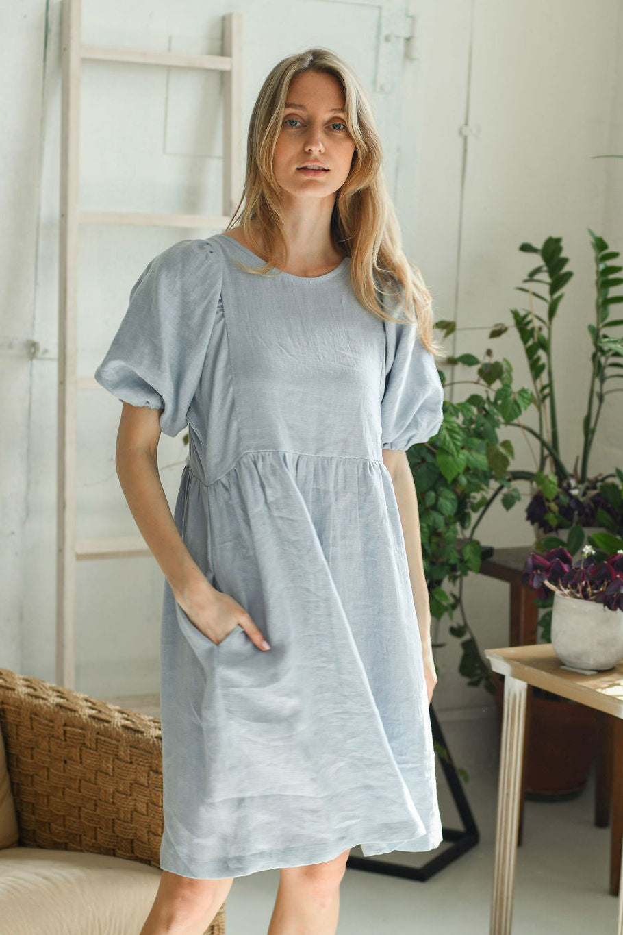 Dusty blue linen dress in natural indoor setting showing knee-length cut, handmade linen dress slow fashion