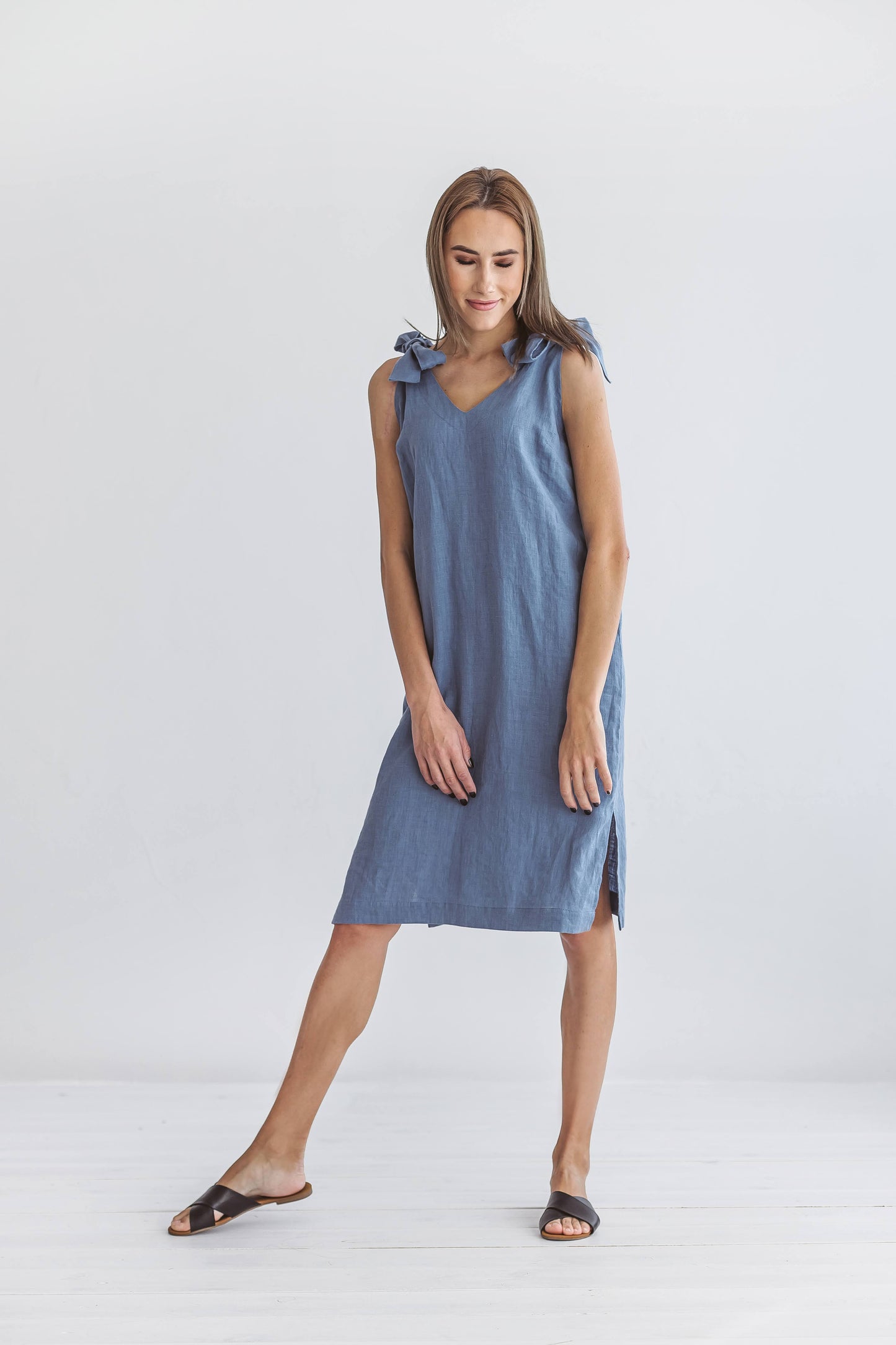 Jeans blue linen dress taking step forward in dynamic pose showing drape, handmade linen dress slow fashion