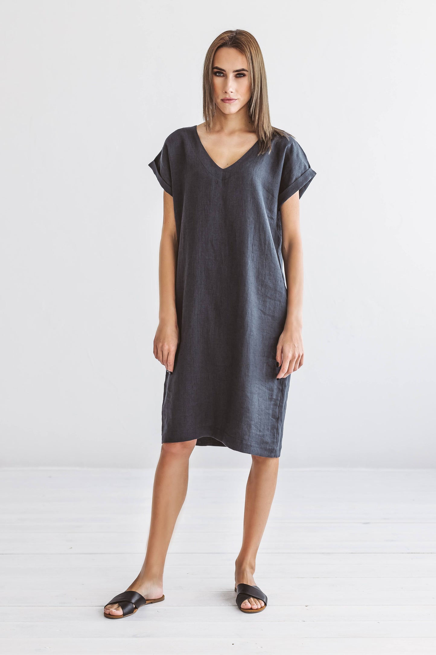 Front view of linen midi dress with V-neckline and relaxed shoulder design.