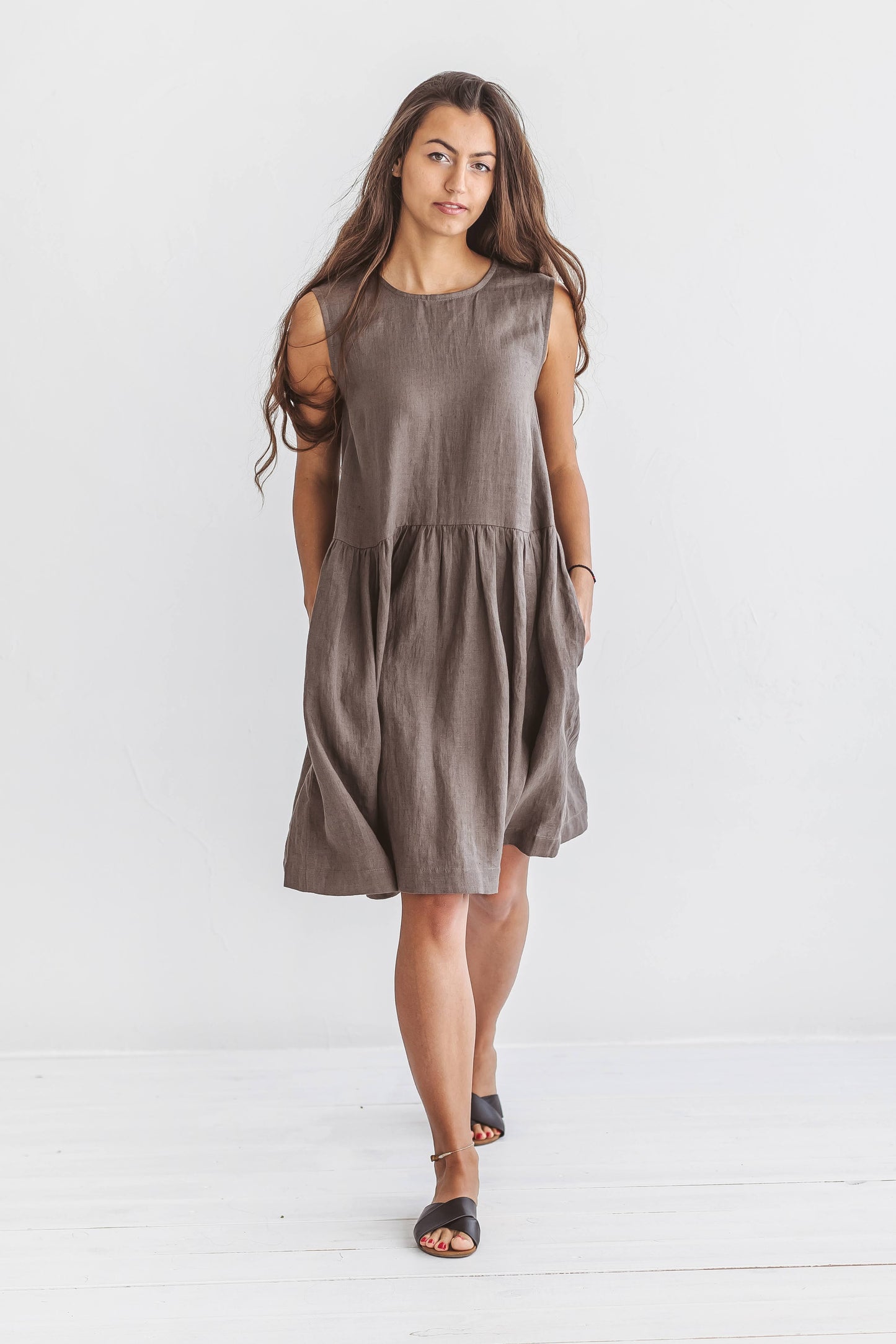 Studio view of the model wearing the beige Kelly linen dress in a relaxed standing pose