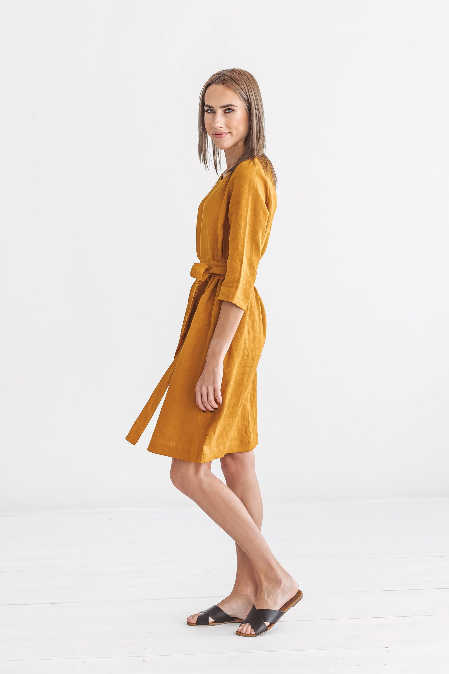 Mustard linen dress full-body side view showing knee-length cut, handmade linen dress slow fashion