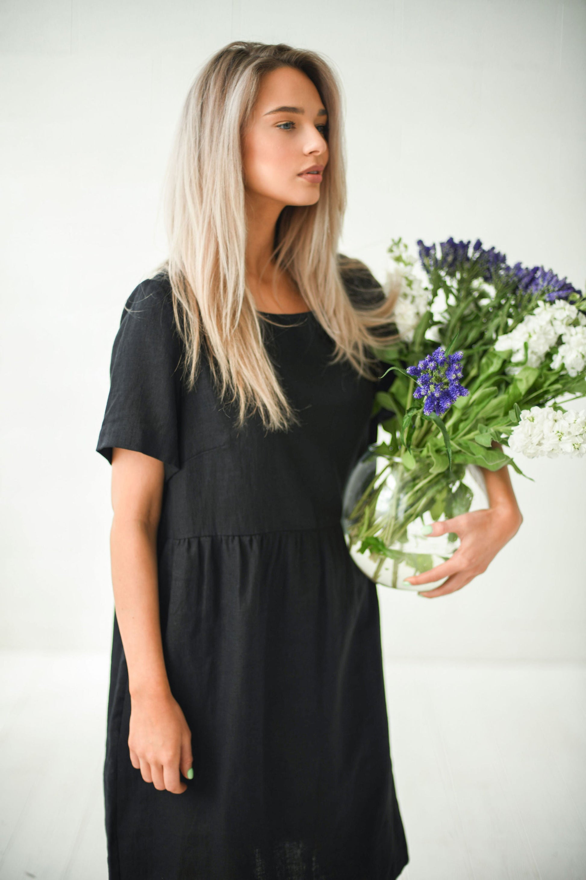 Alba black oversized linen dress closeup side view holding flowers handmade linen dress slow fashion