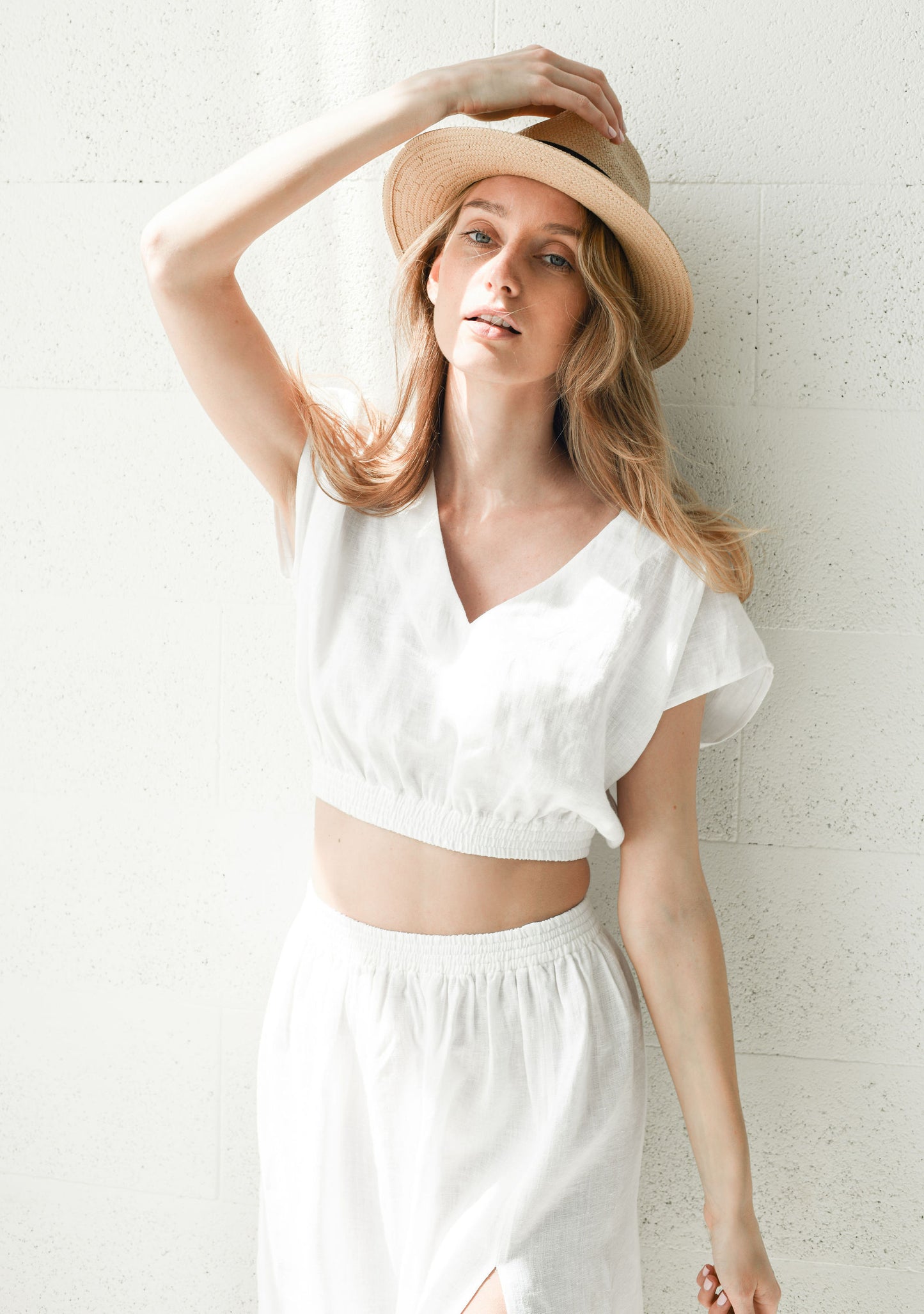 Close-up view showing the gathered waist and soft drape of a linen skirt in natural light.