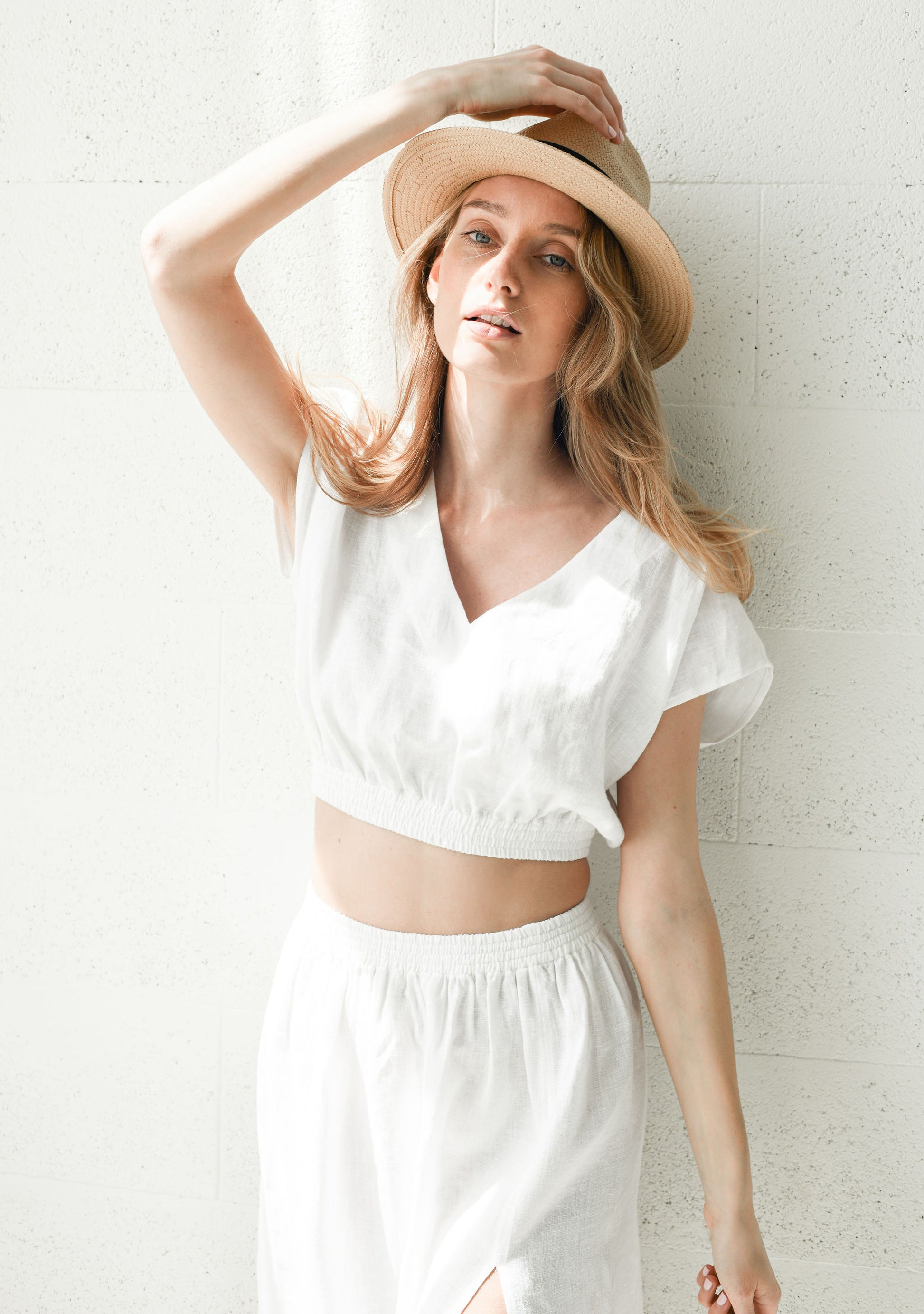 Close-up view showing the gathered waist and soft drape of a linen skirt in natural light.