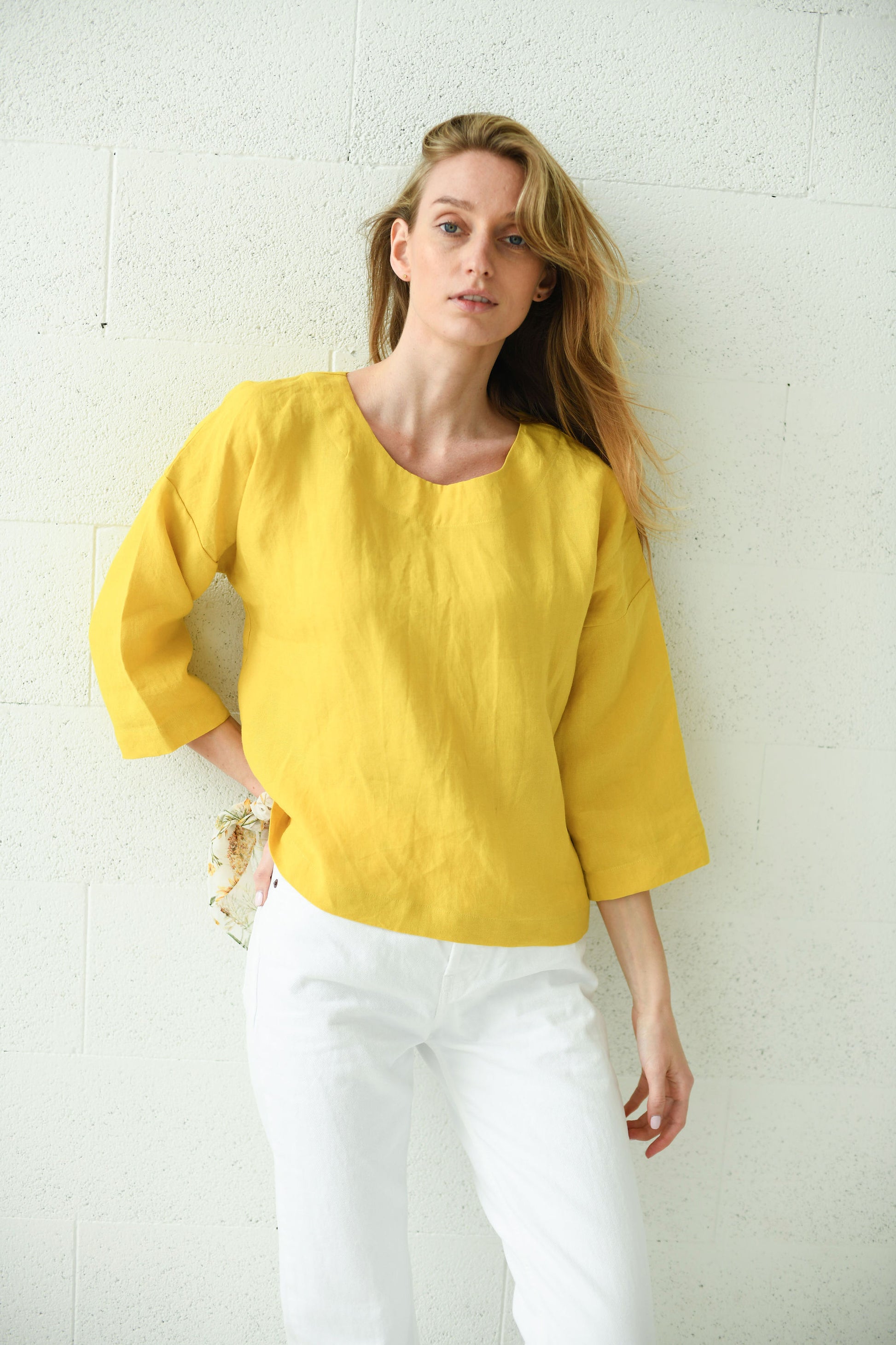 Yellow linen top front standing view minimalist setting, handmade linen top slow fashion