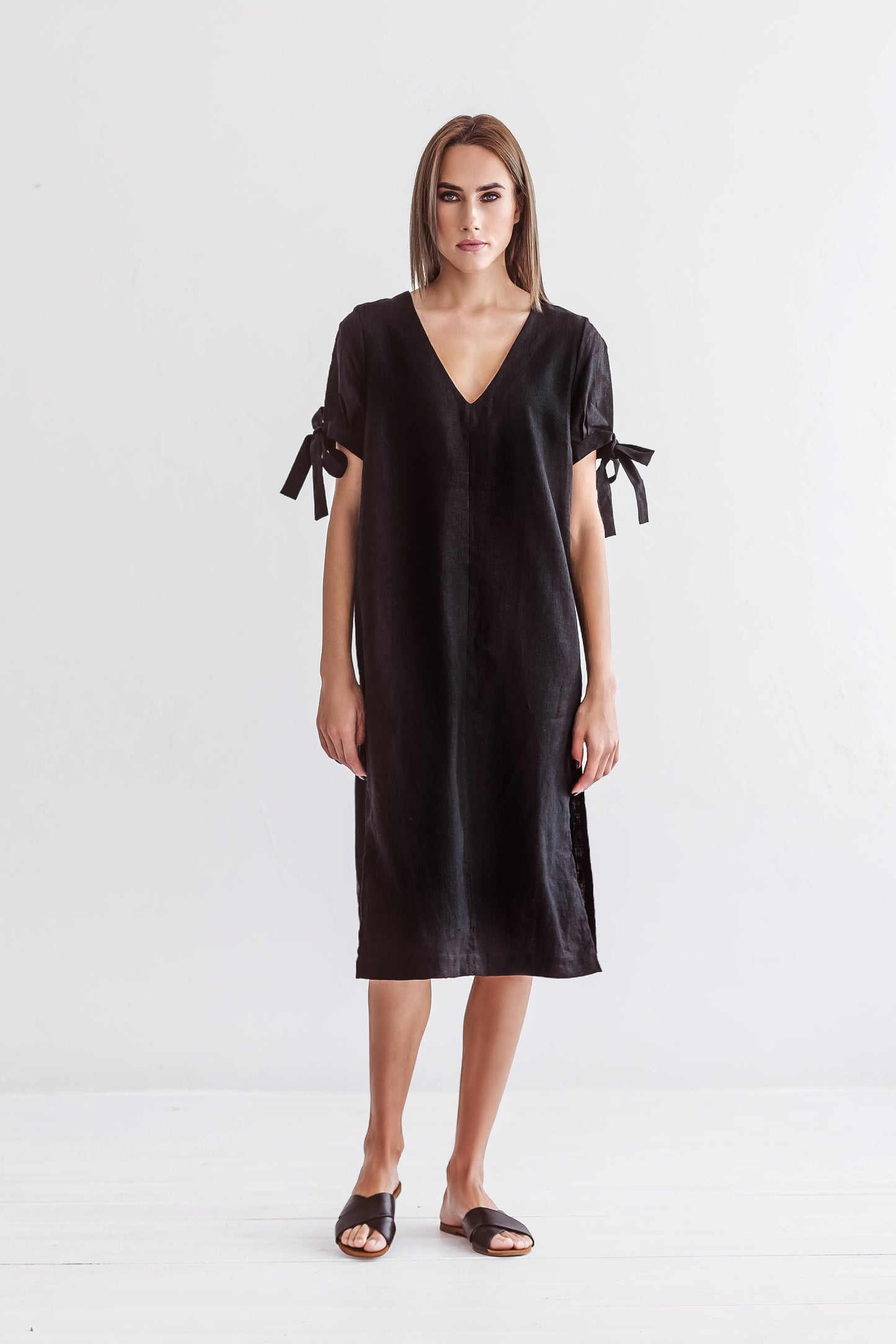 Black linen midi dress front view showing V-neckline and relaxed silhouette, handmade linen dress slow fashion