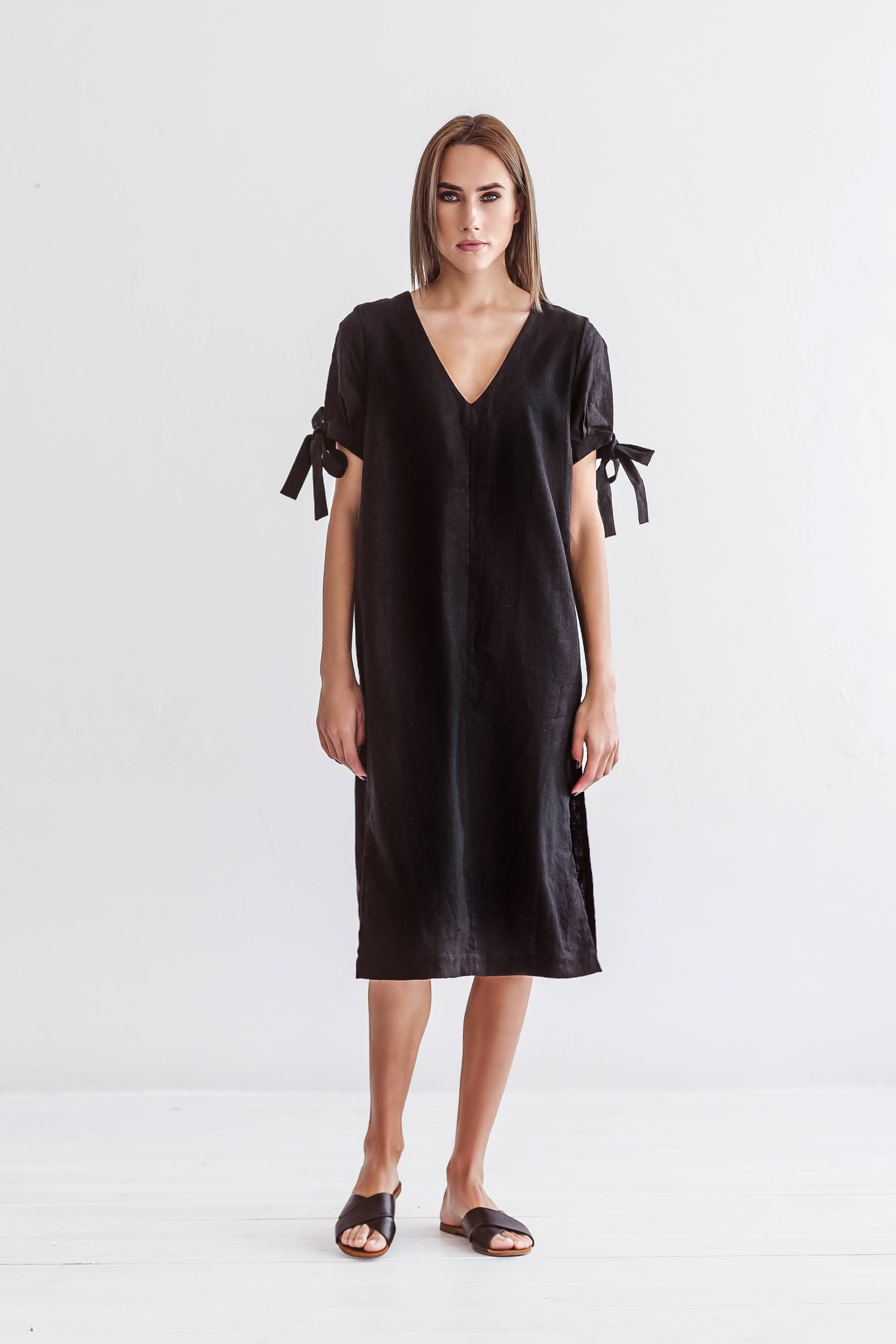 Black linen midi dress front view showing V-neckline and relaxed silhouette, handmade linen dress slow fashion