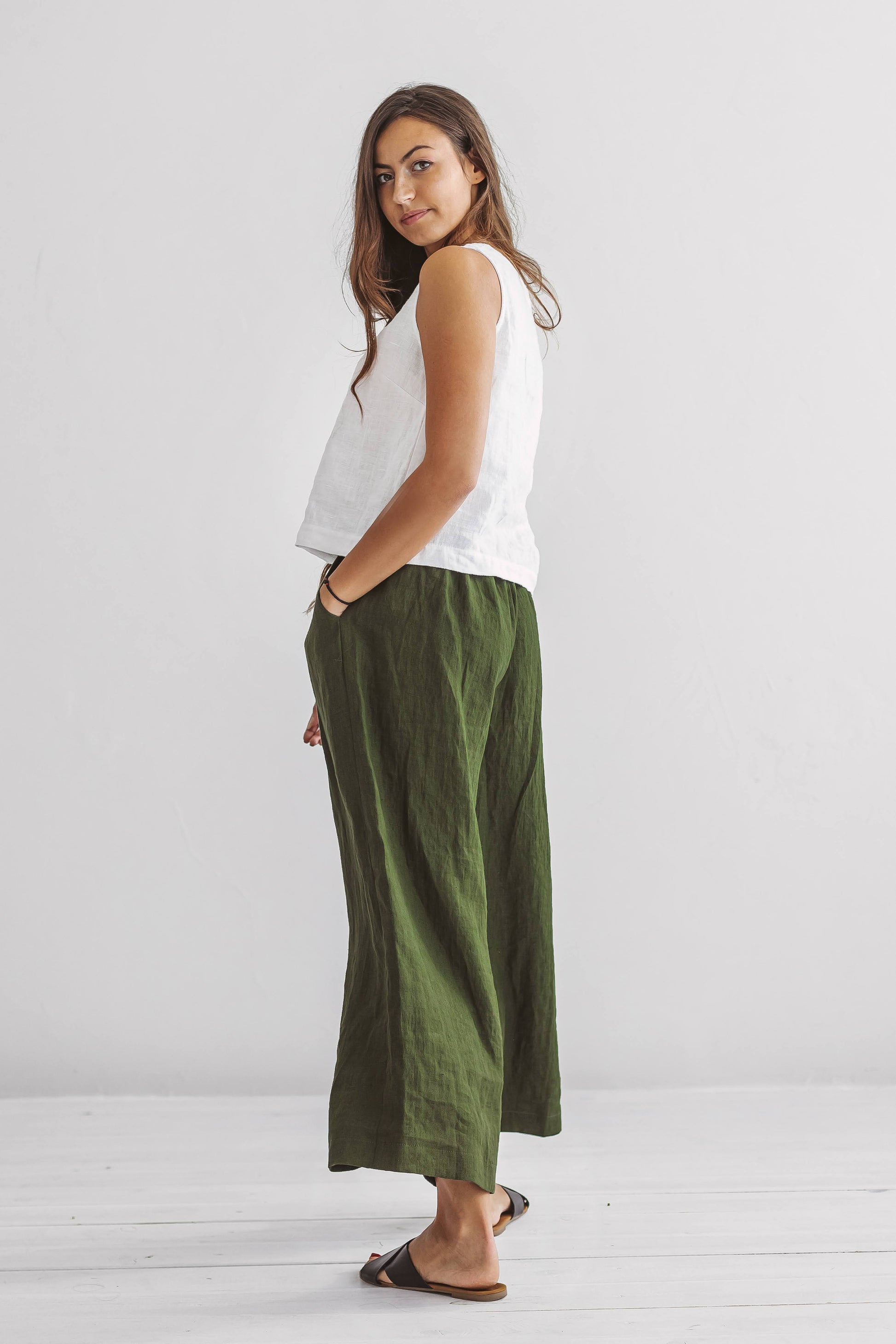Forest green linen pants profile view showcasing wide-leg shape and relaxed silhouette, handmade linen pants slow fashion