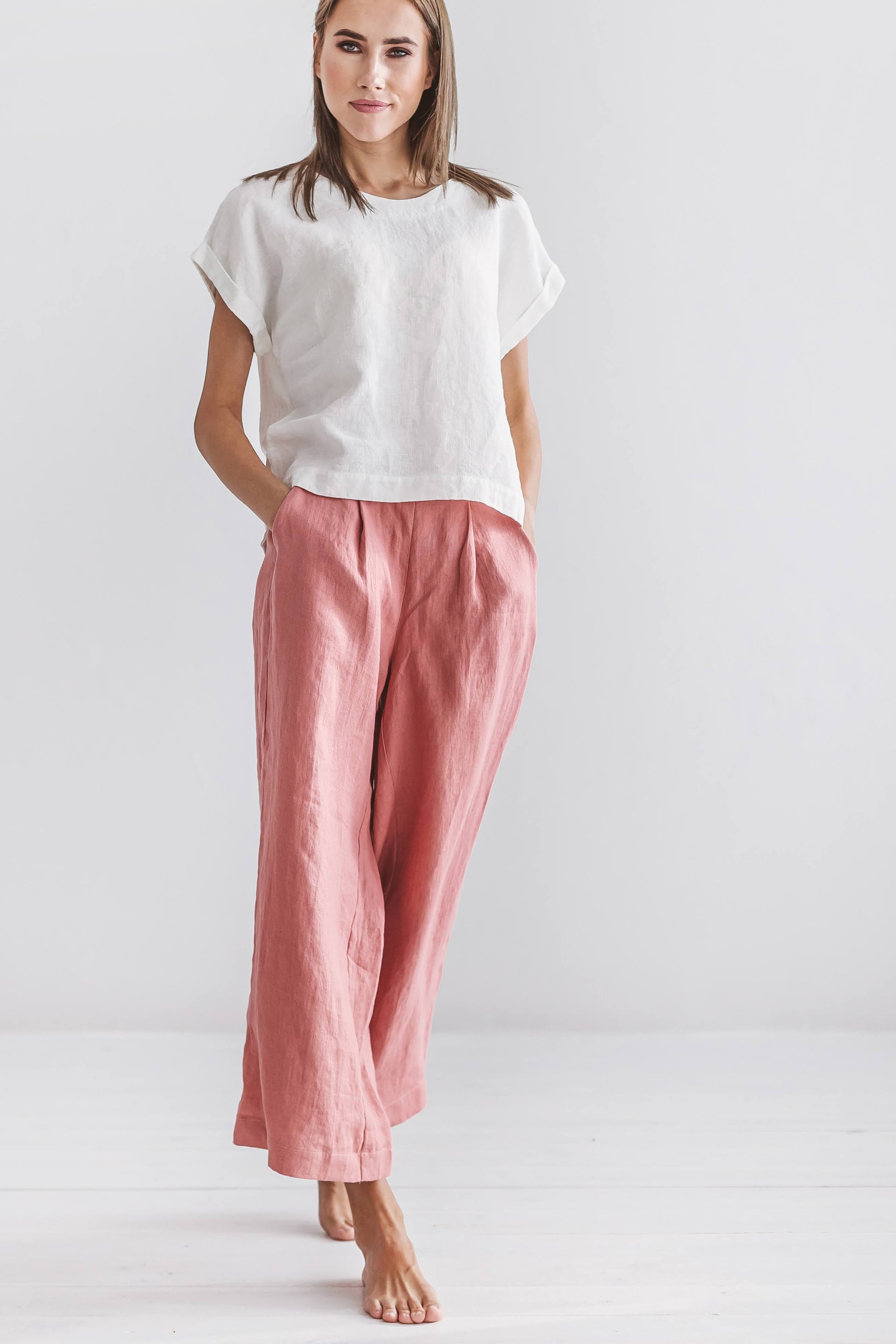 Salmon linen pants side-to-front angle showing loose drape and cropped length, handmade linen pants slow fashion