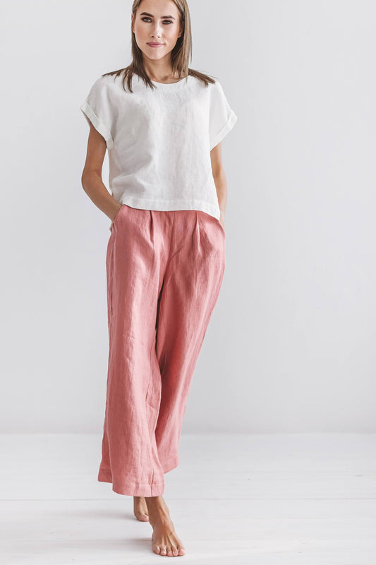 Salmon linen pants side-to-front angle showing loose drape and cropped length, handmade linen pants slow fashion
