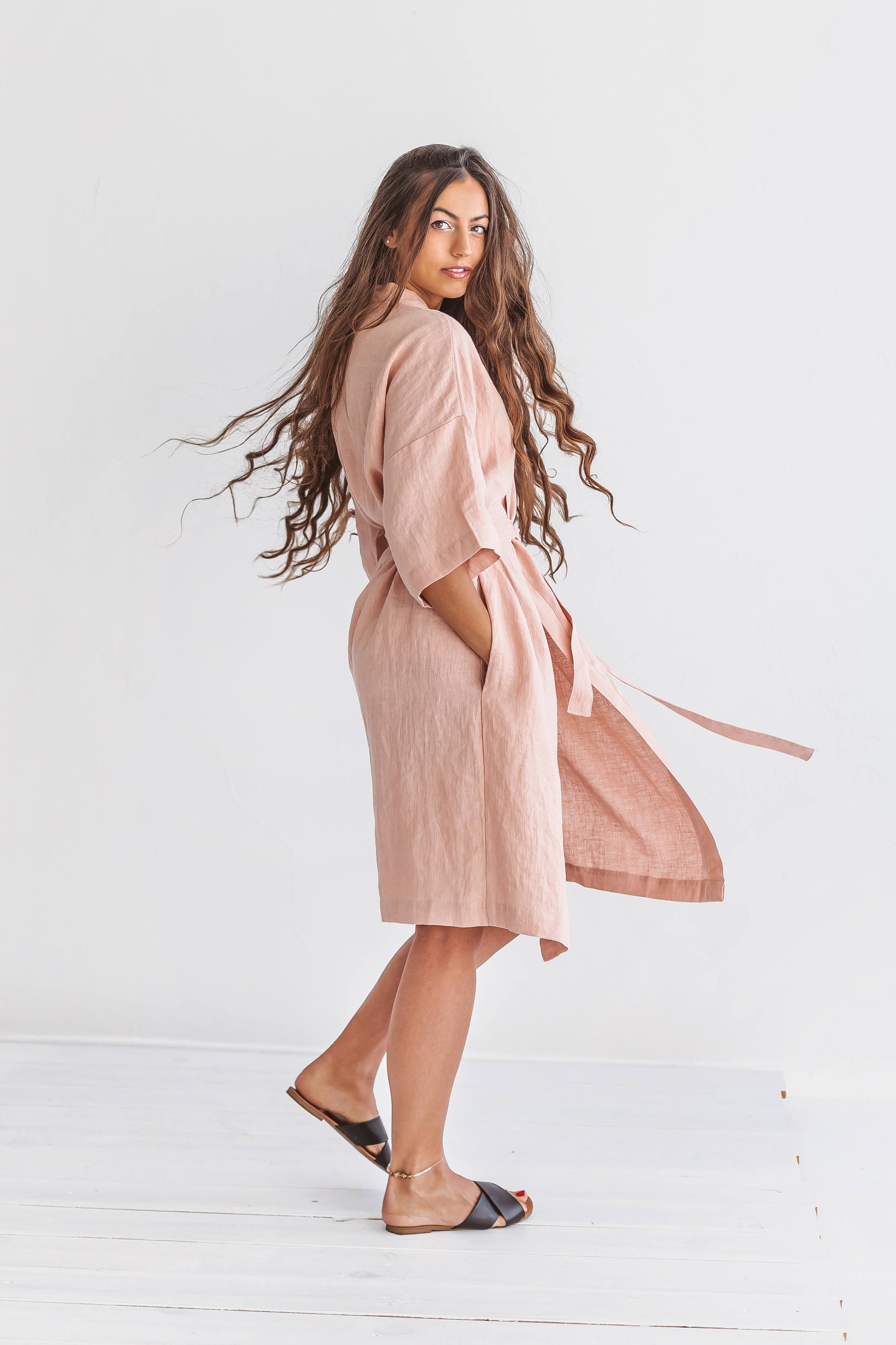 Pastel pink linen robe standing pose showing wide sleeves and relaxed fit, handmade linen robe slow fashion