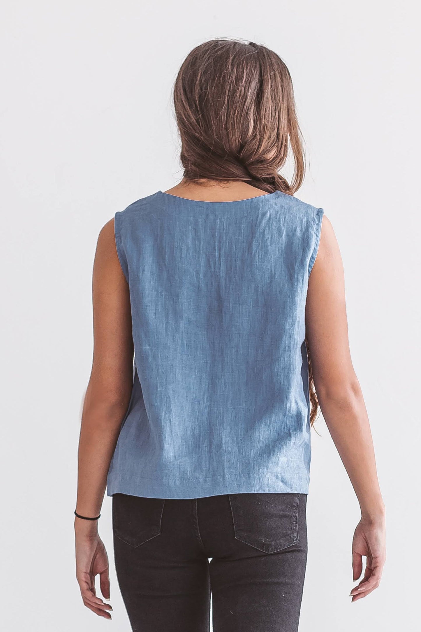 Back view of sleeveless linen top with relaxed drape, ethical women’s clothing made from natural fibers.