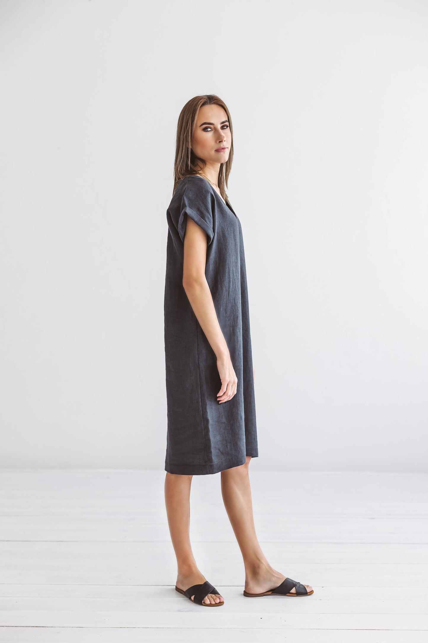 Back view of linen midi dress with relaxed straight silhouette and soft sleeves.