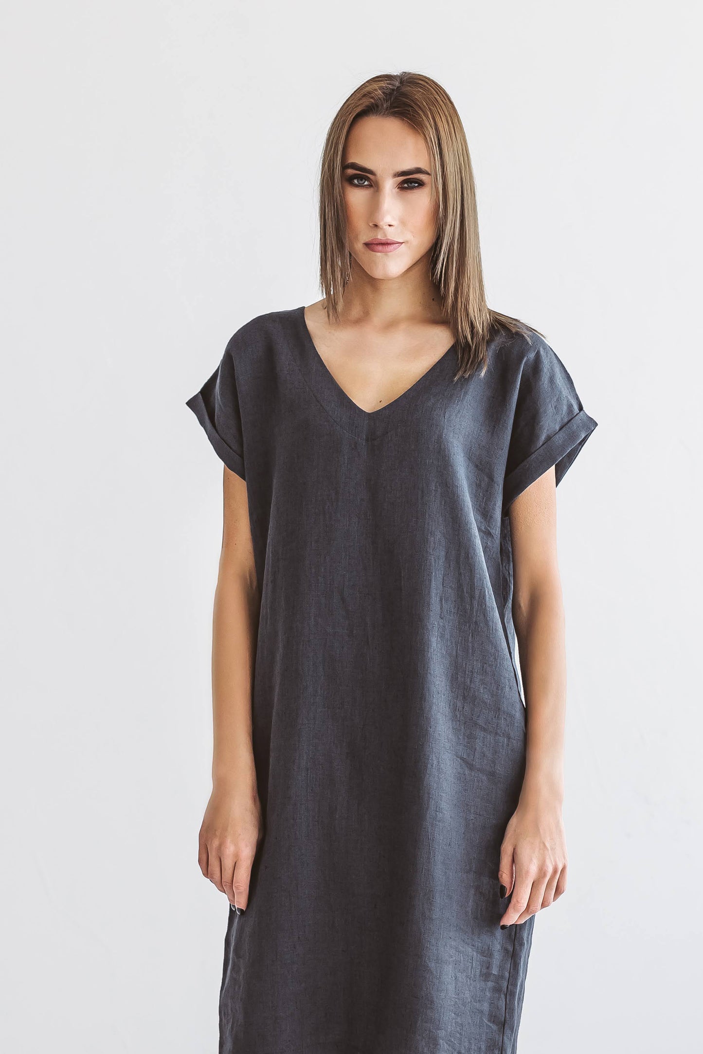 Side angle of linen midi dress highlighting straight midi silhouette and natural movement.