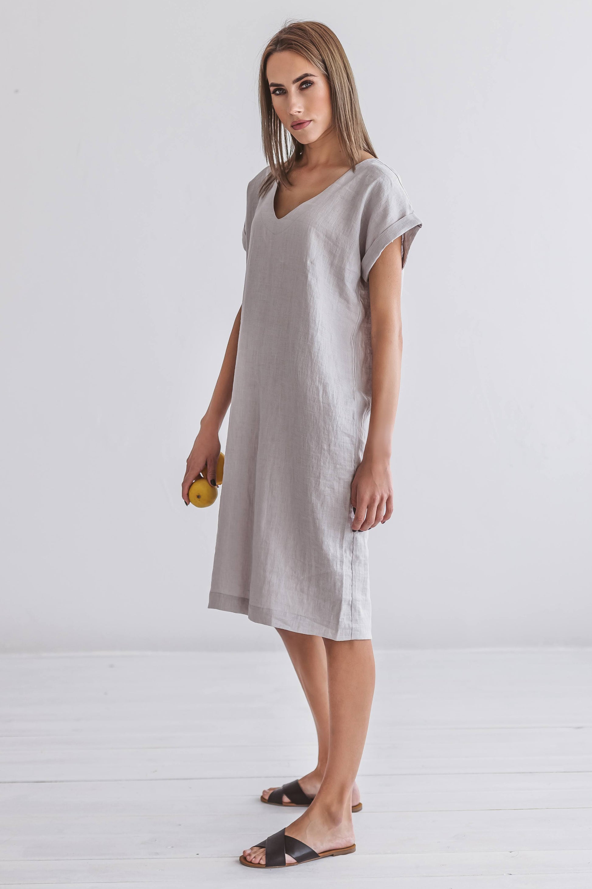 Three-quarter studio view of linen midi dress with a soft, easy silhouette and midi length.