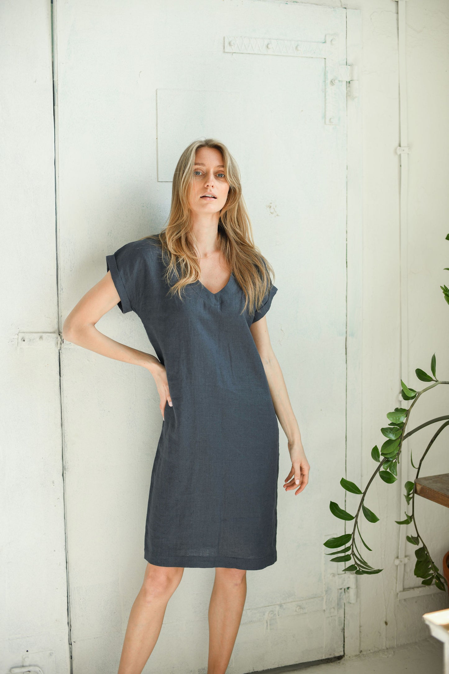 Side indoor view of linen midi dress showing fluid drape and relaxed fit.