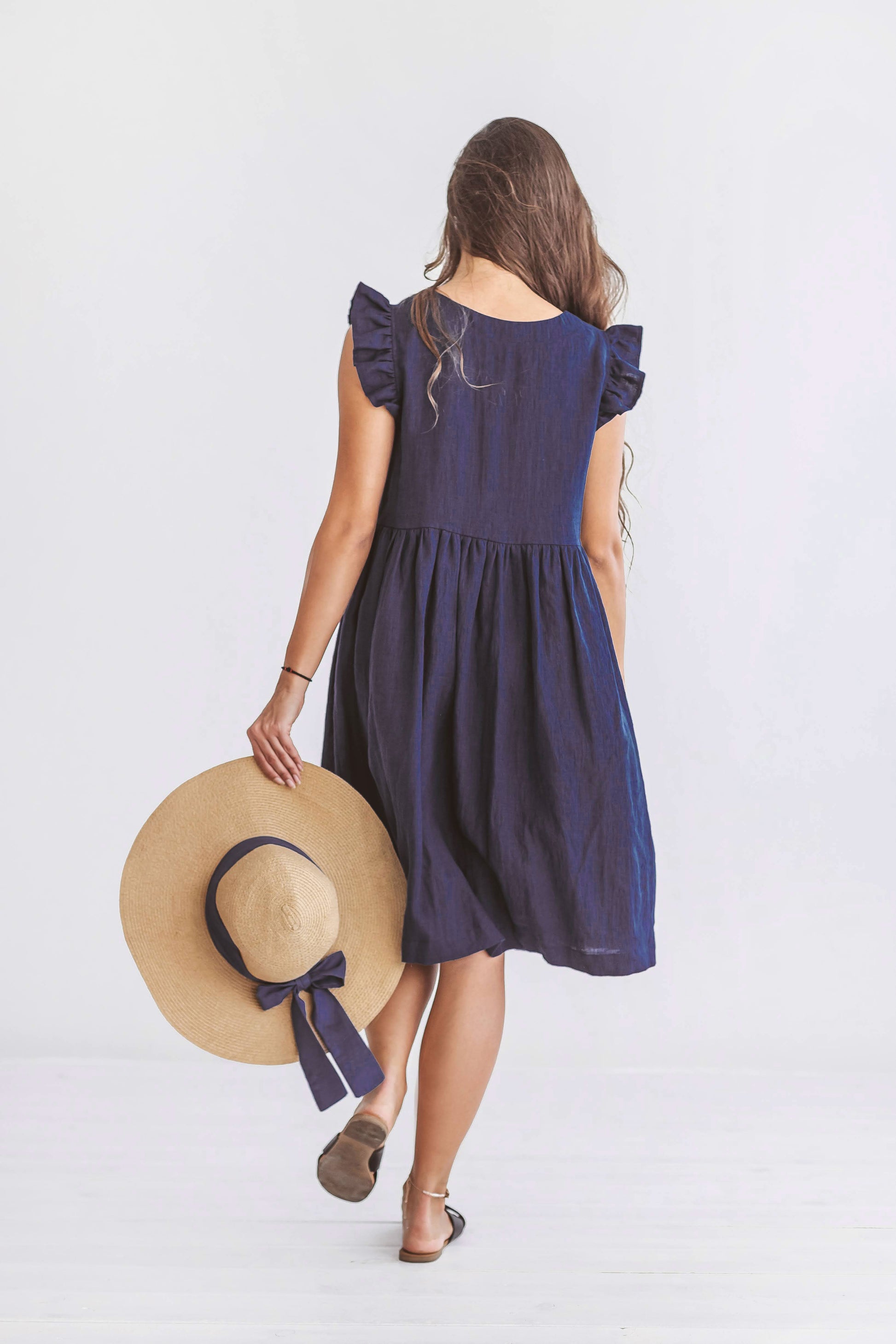 Front view of linen dress with relaxed gathered silhouette and soft shoulder ruffles.