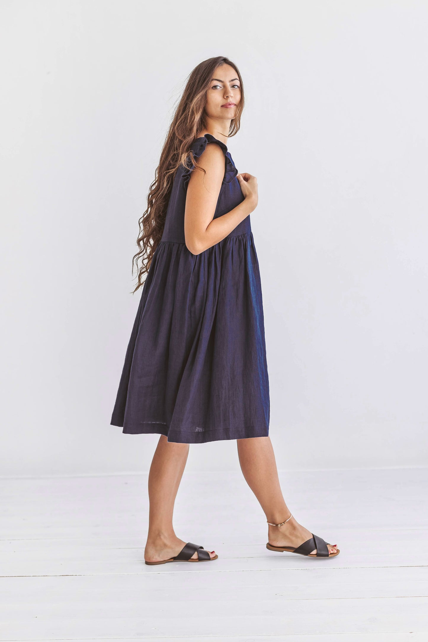 Minimalist standing pose highlighting the linen dress’s relaxed gathered fit and soft lines.