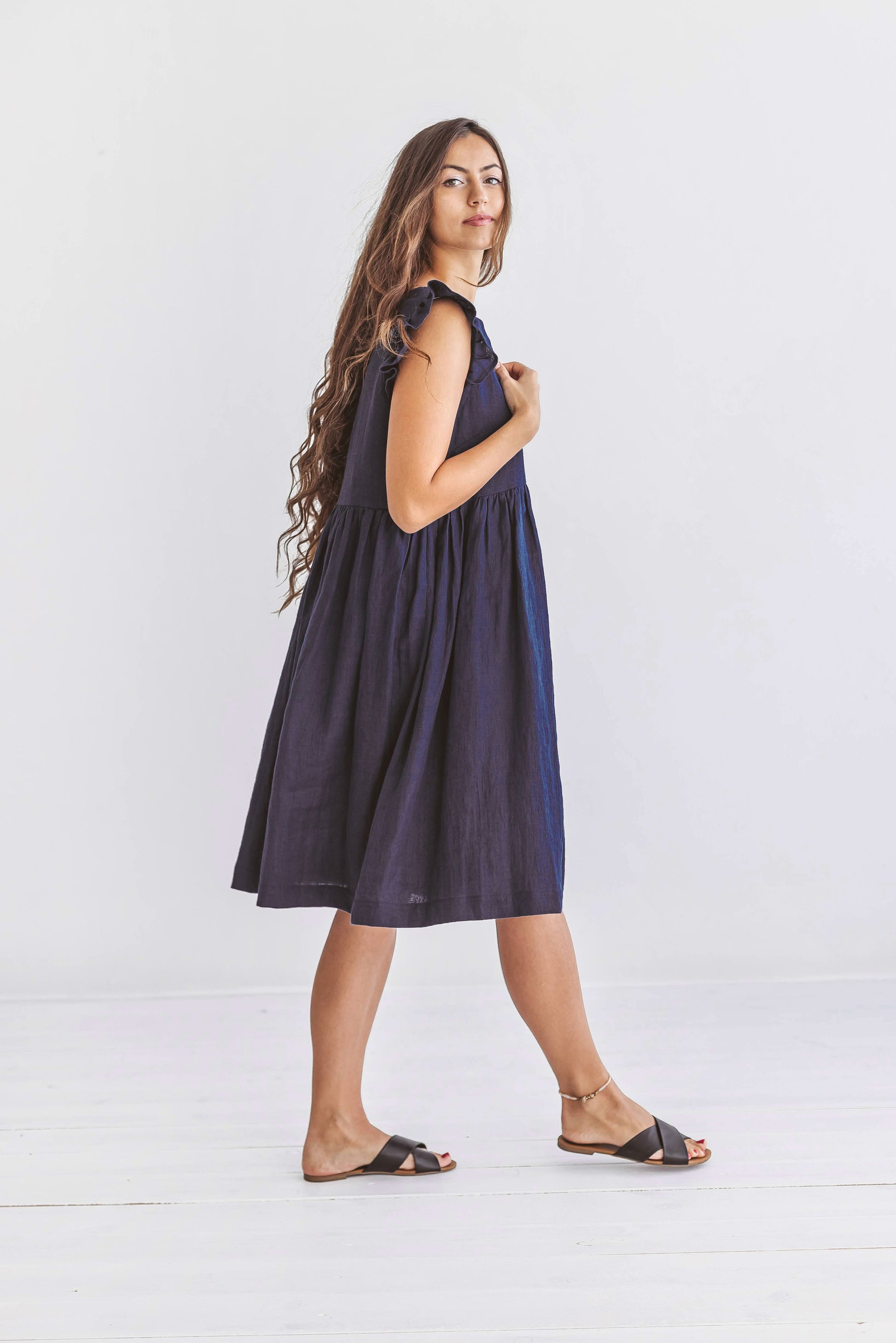Minimalist standing pose highlighting the linen dress’s relaxed gathered fit and soft lines.