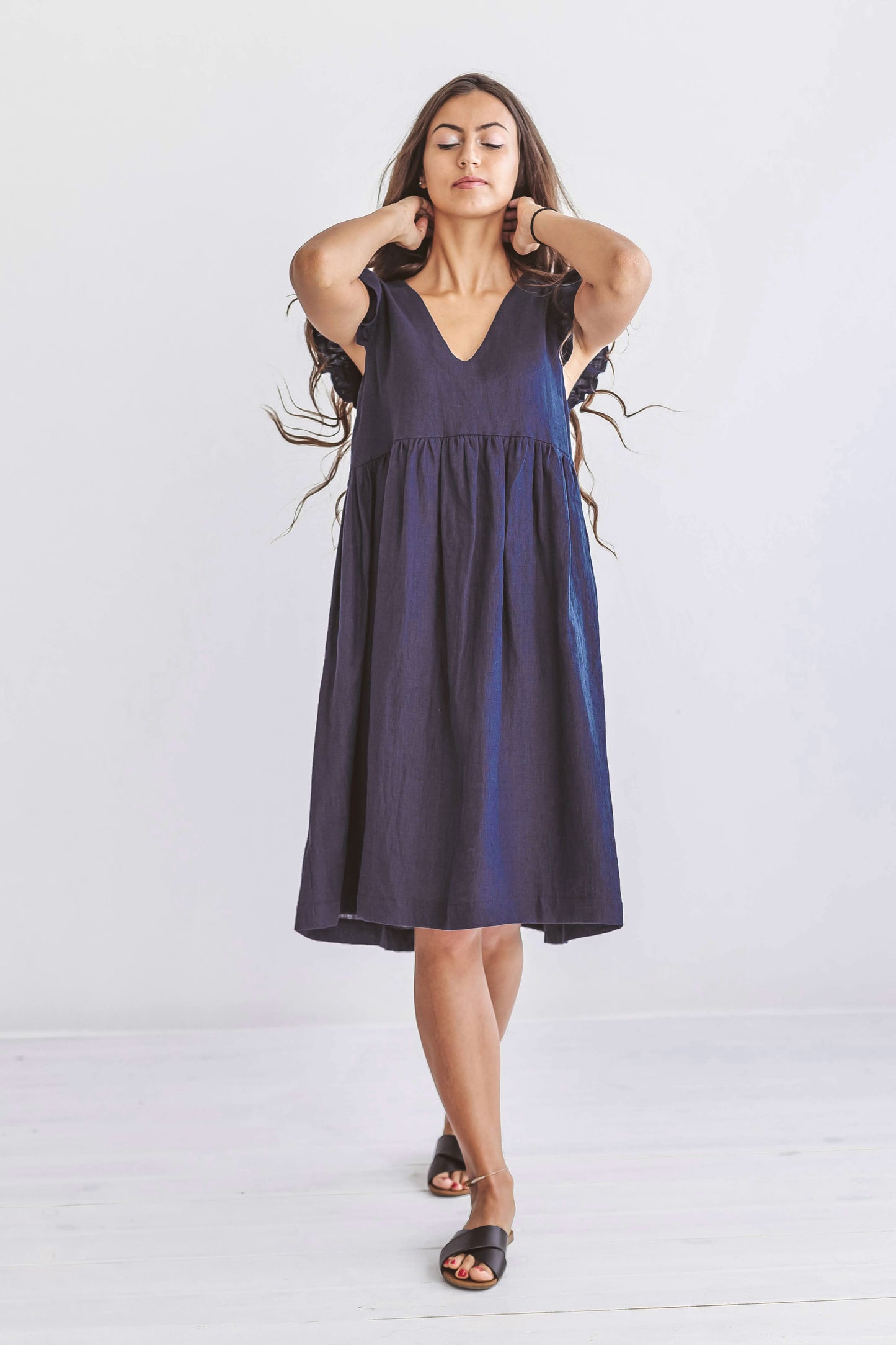 Full-body front view featuring the dress’s relaxed silhouette and deep V-neckline.