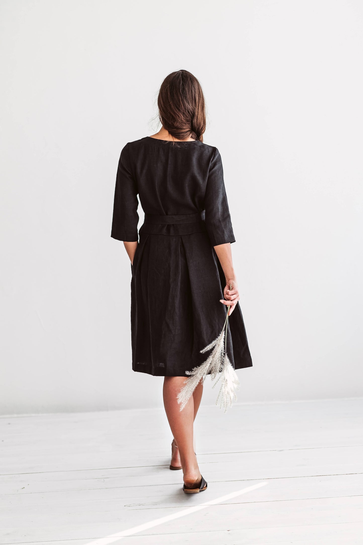Back view of linen dress showing relaxed A-line silhouette and extended short sleeves.