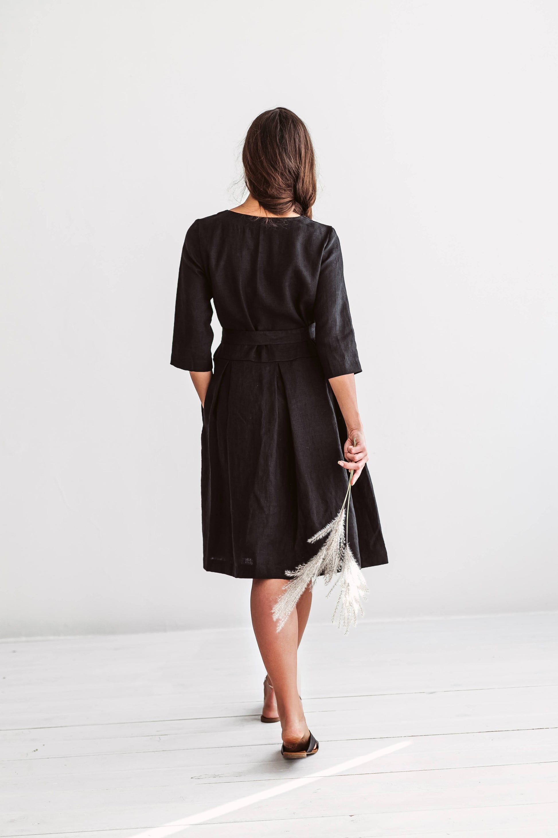 Back view of linen dress showing relaxed A-line silhouette and extended short sleeves.