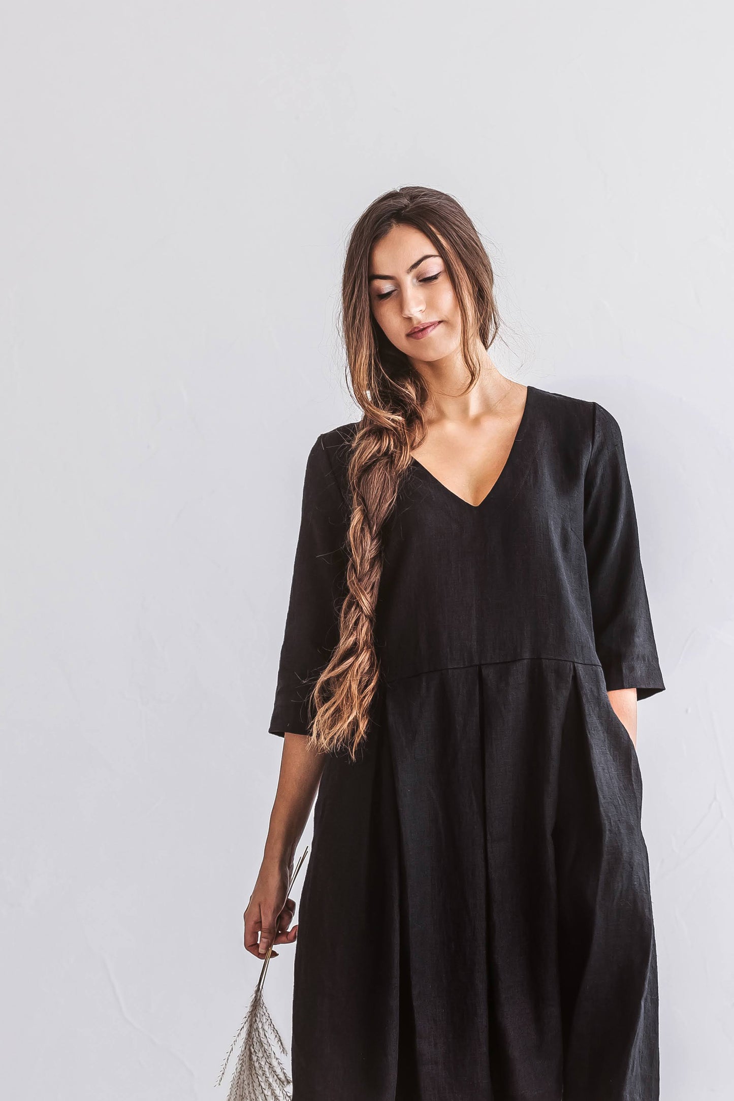 Close-up view of linen dress with soft V-neckline and fluid gathered shape.