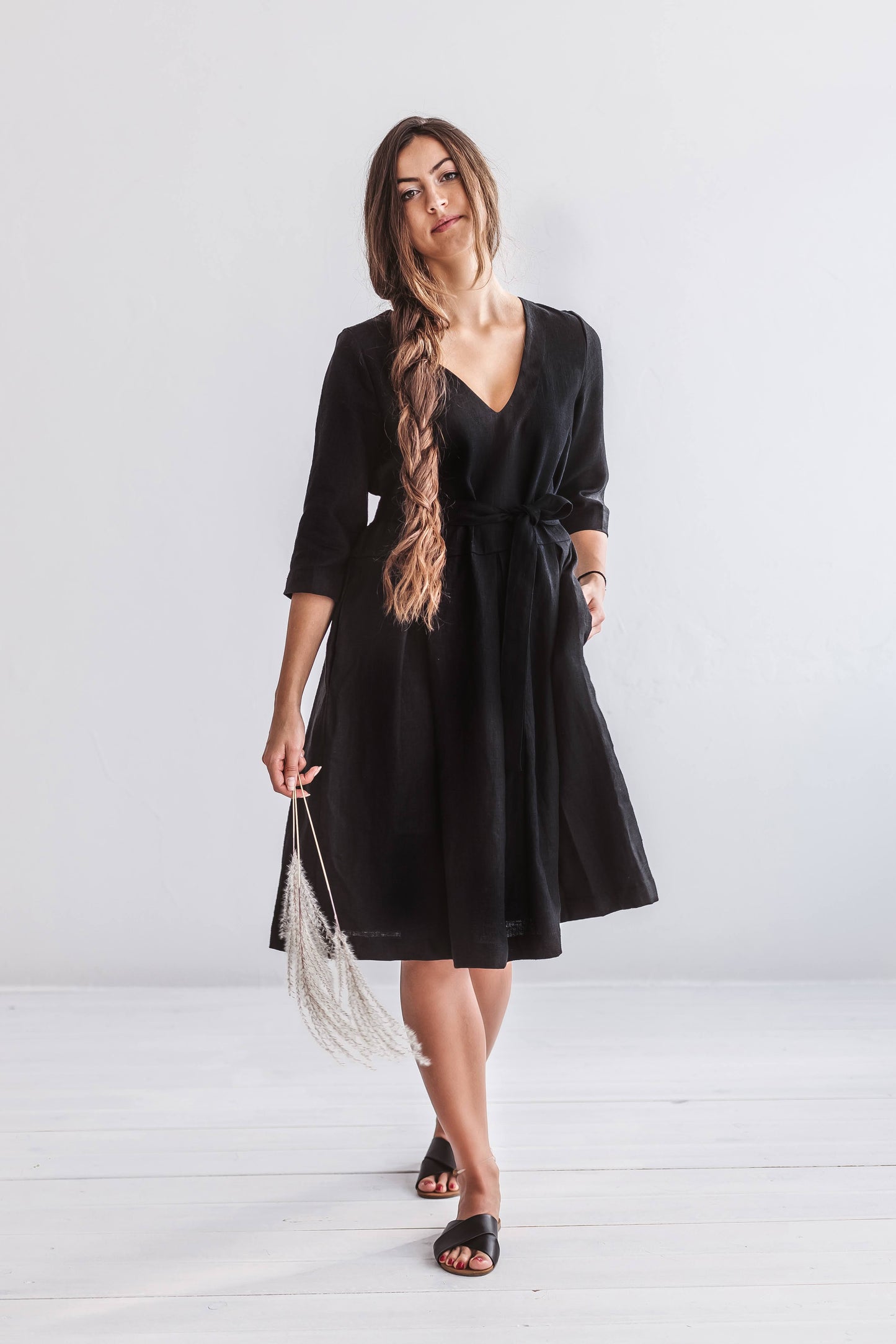 Minimalist standing pose highlighting the dress’s A-line silhouette and V-neckline.