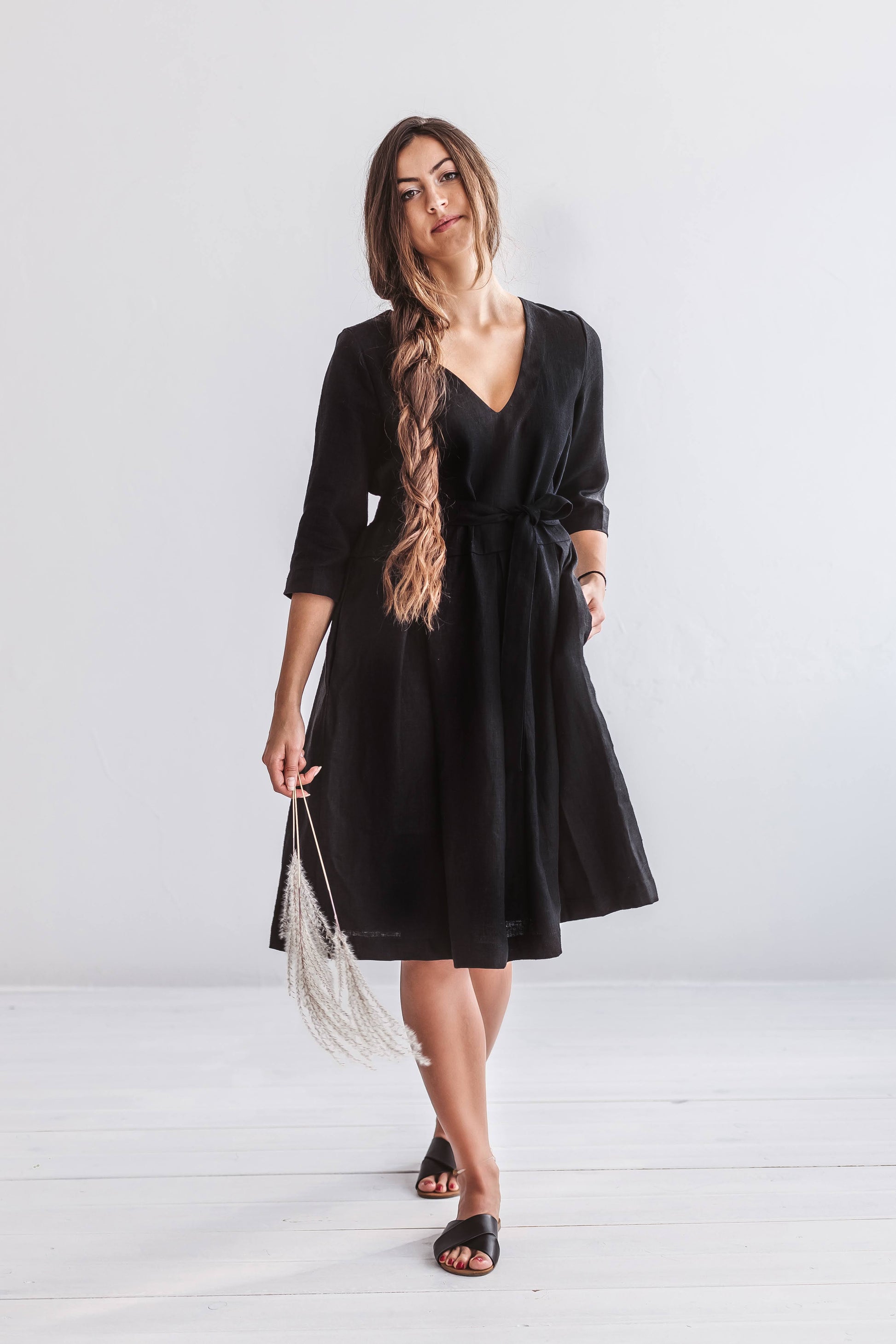 Minimalist standing pose highlighting the dress’s A-line silhouette and V-neckline.