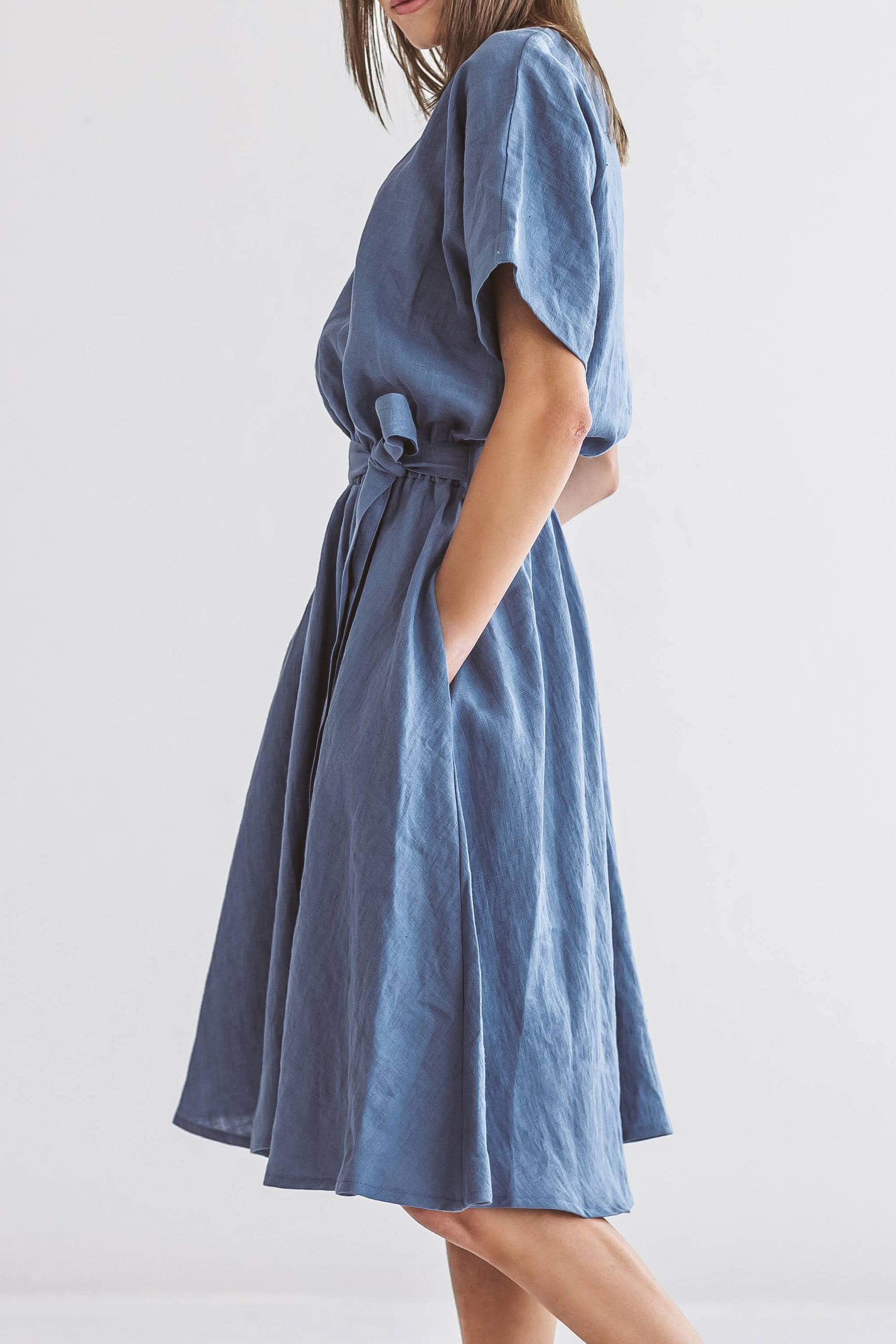 Model wearing the Kate linen dress in side profile, showing sleeve shape and natural movement