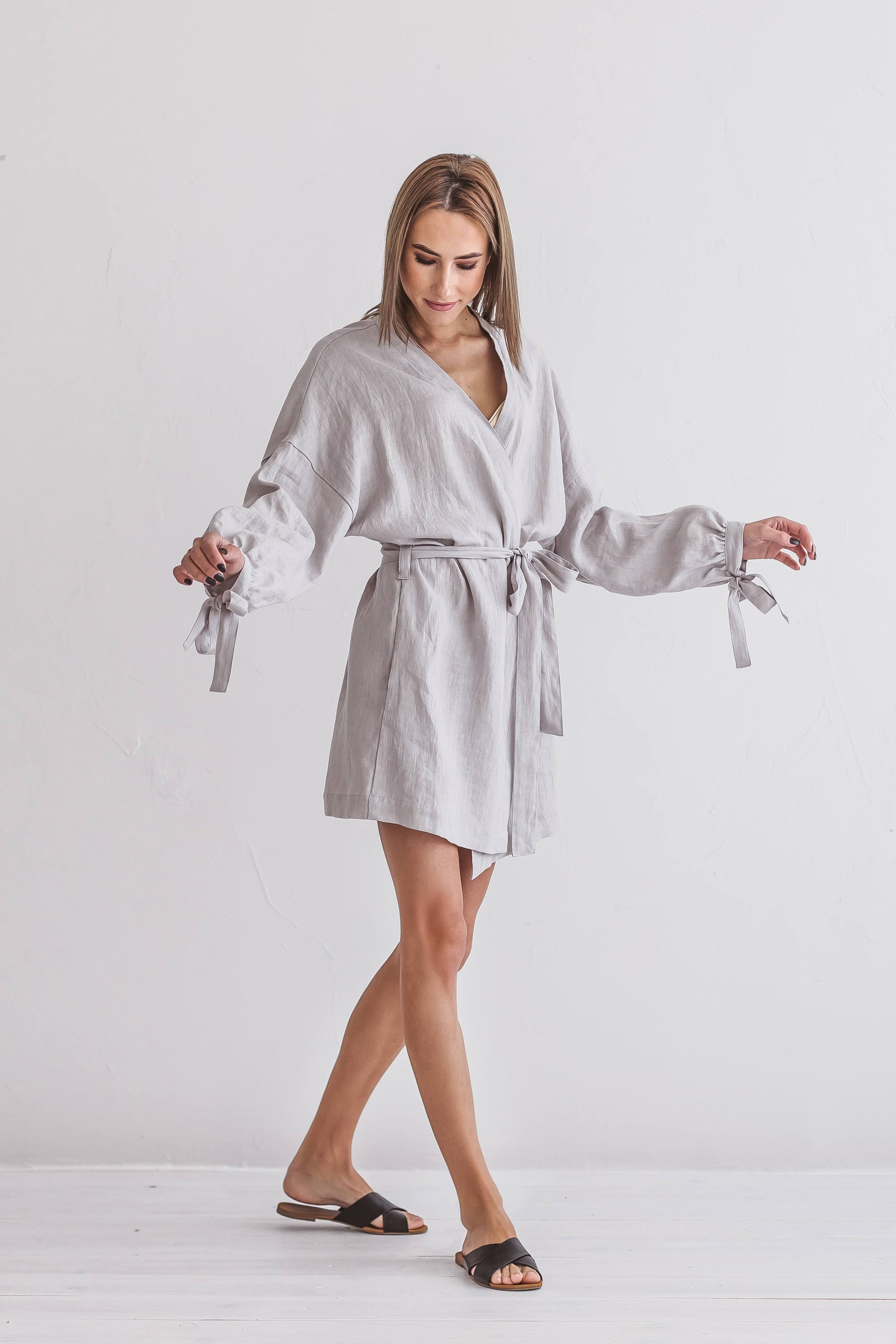 Full-body view of a woman wearing a soft-draping linen kimono robe, handmade linen clothing slow fashion