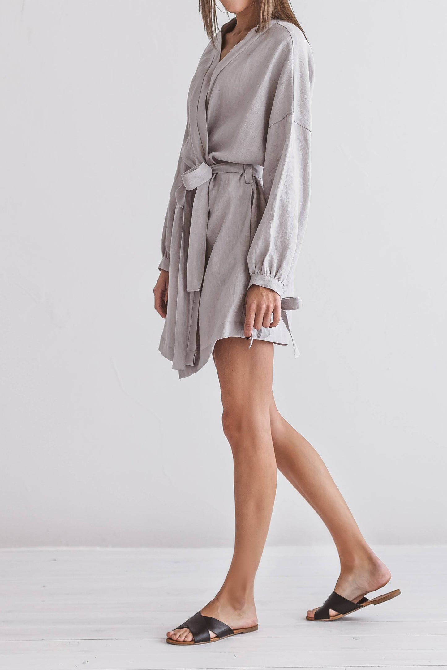 Half-profile view of a woman in a linen kimono robe with belt, handmade linen clothing slow fashion