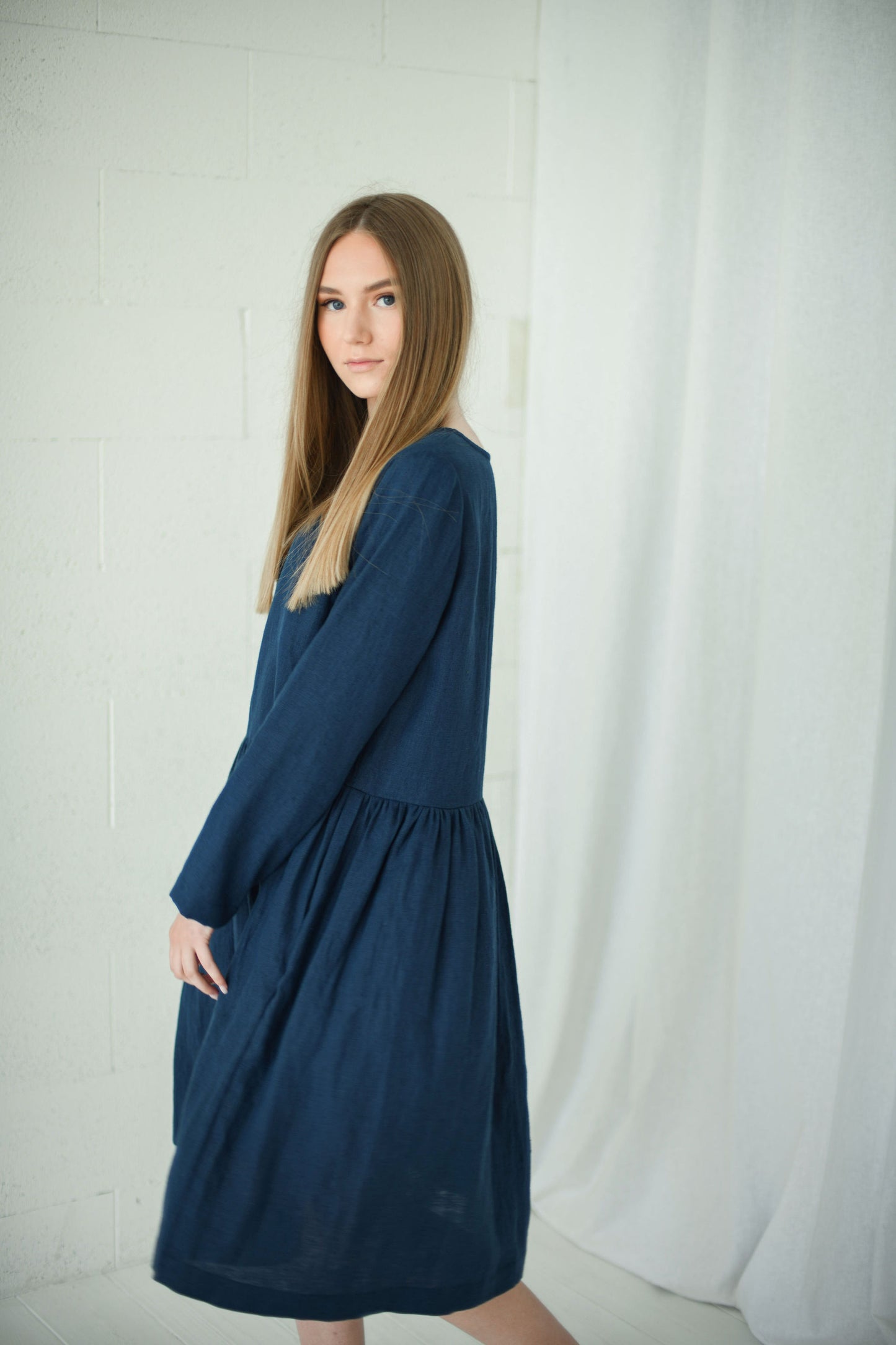Model wearing relaxed long-sleeve linen dress, back view