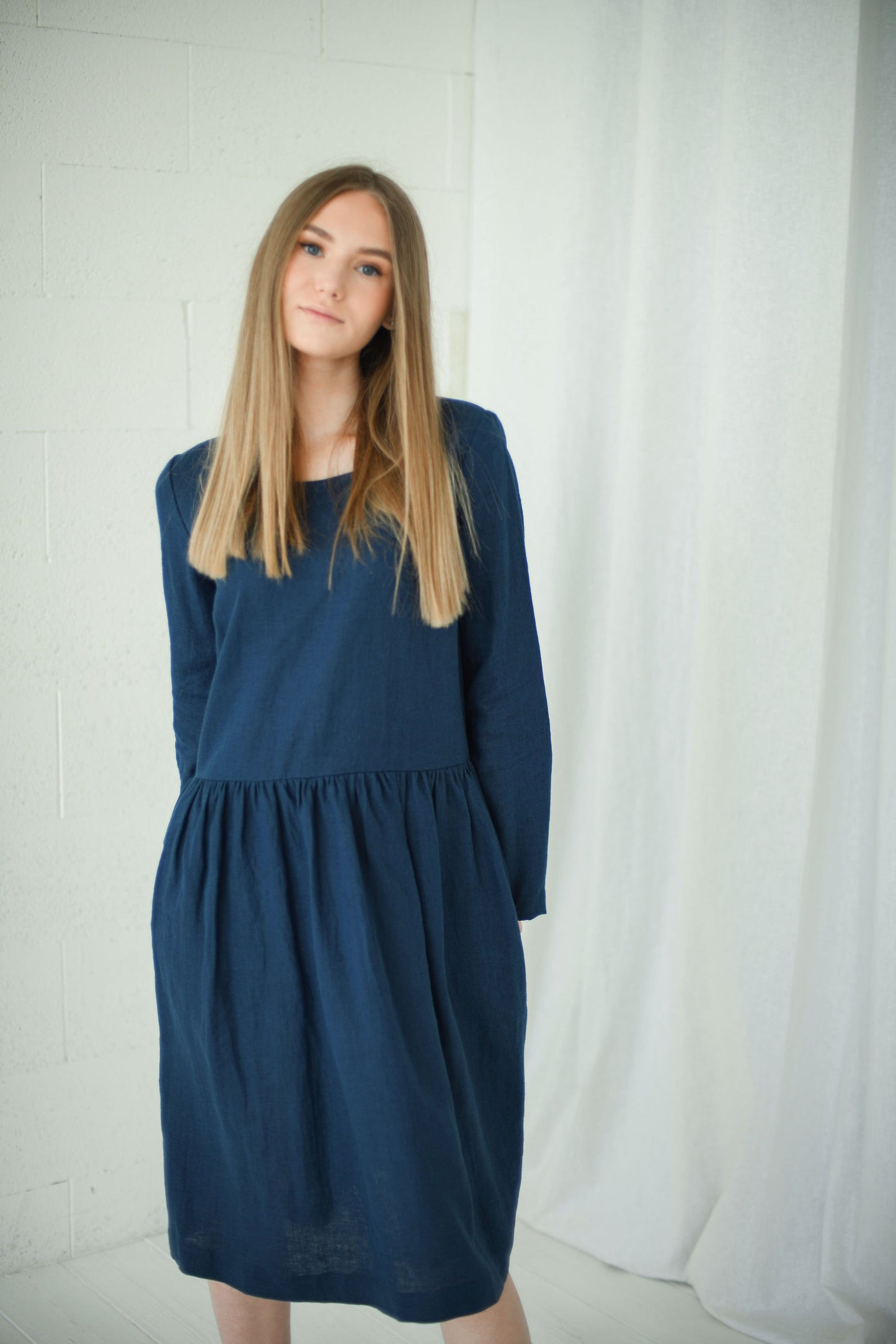 Full-body view of model in relaxed long-sleeve linen dress