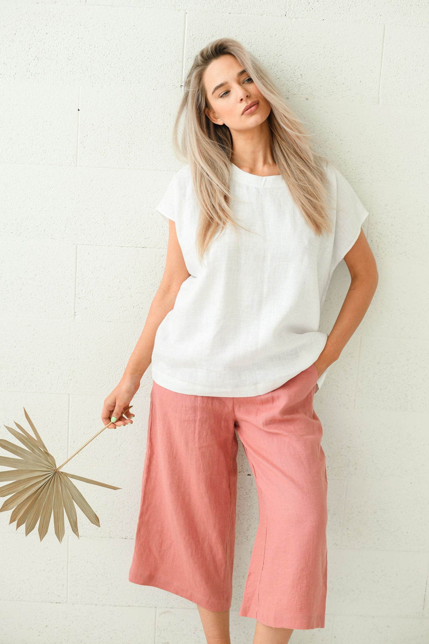 White linen top smiling pose holding natural accessory, handmade linen top slow fashion