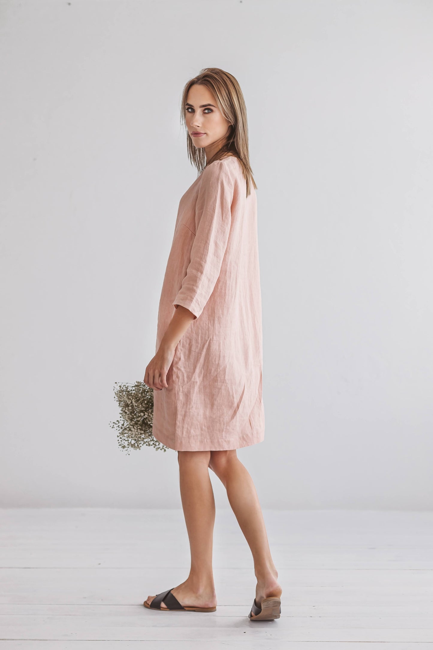 Woman wearing Melinda linen dress, side view