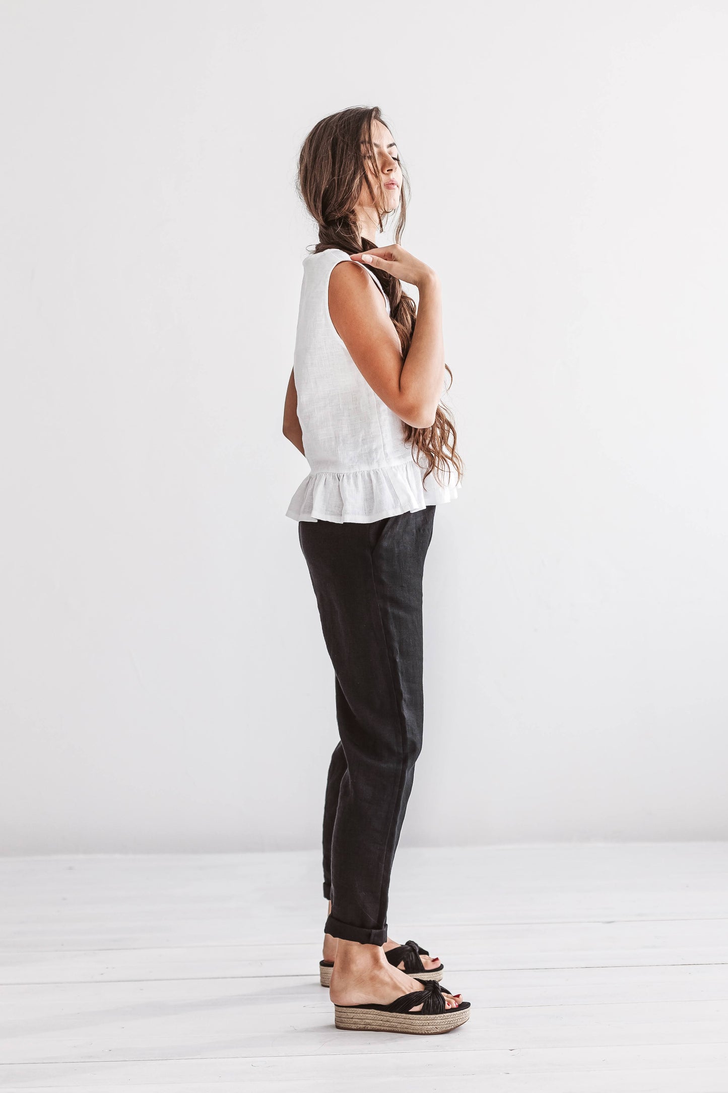 Black linen pants full-body side view studio showing relaxed drape, handmade linen pants slow fashion