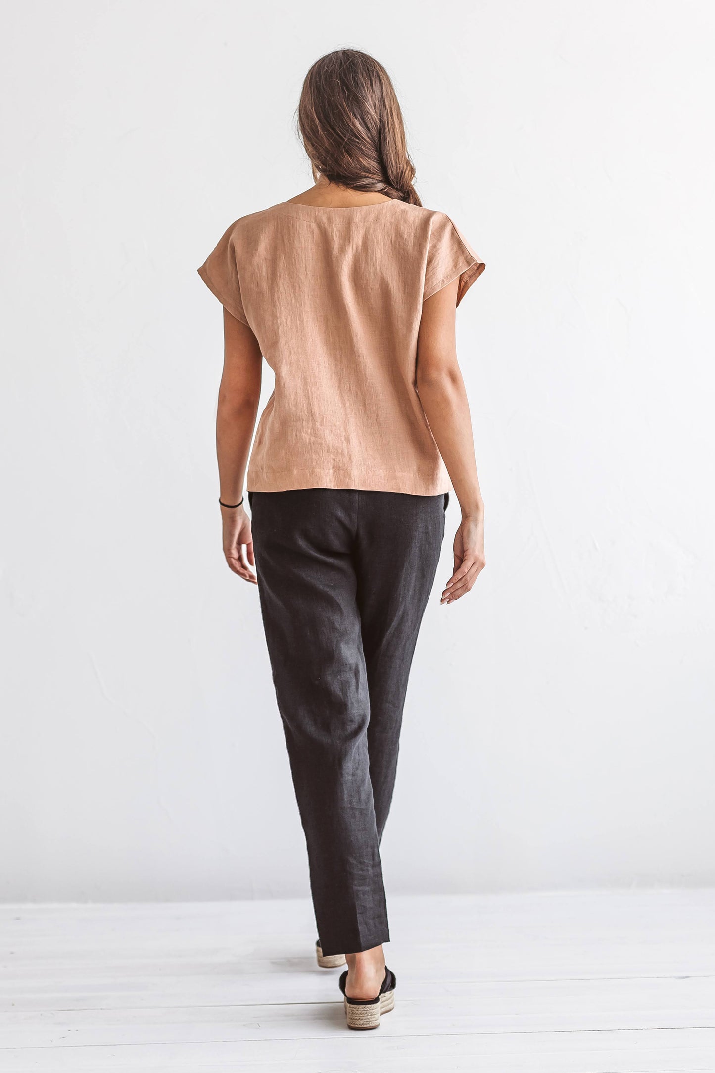 Black linen pants back view studio showing relaxed fit silhouette, handmade linen pants slow fashion
