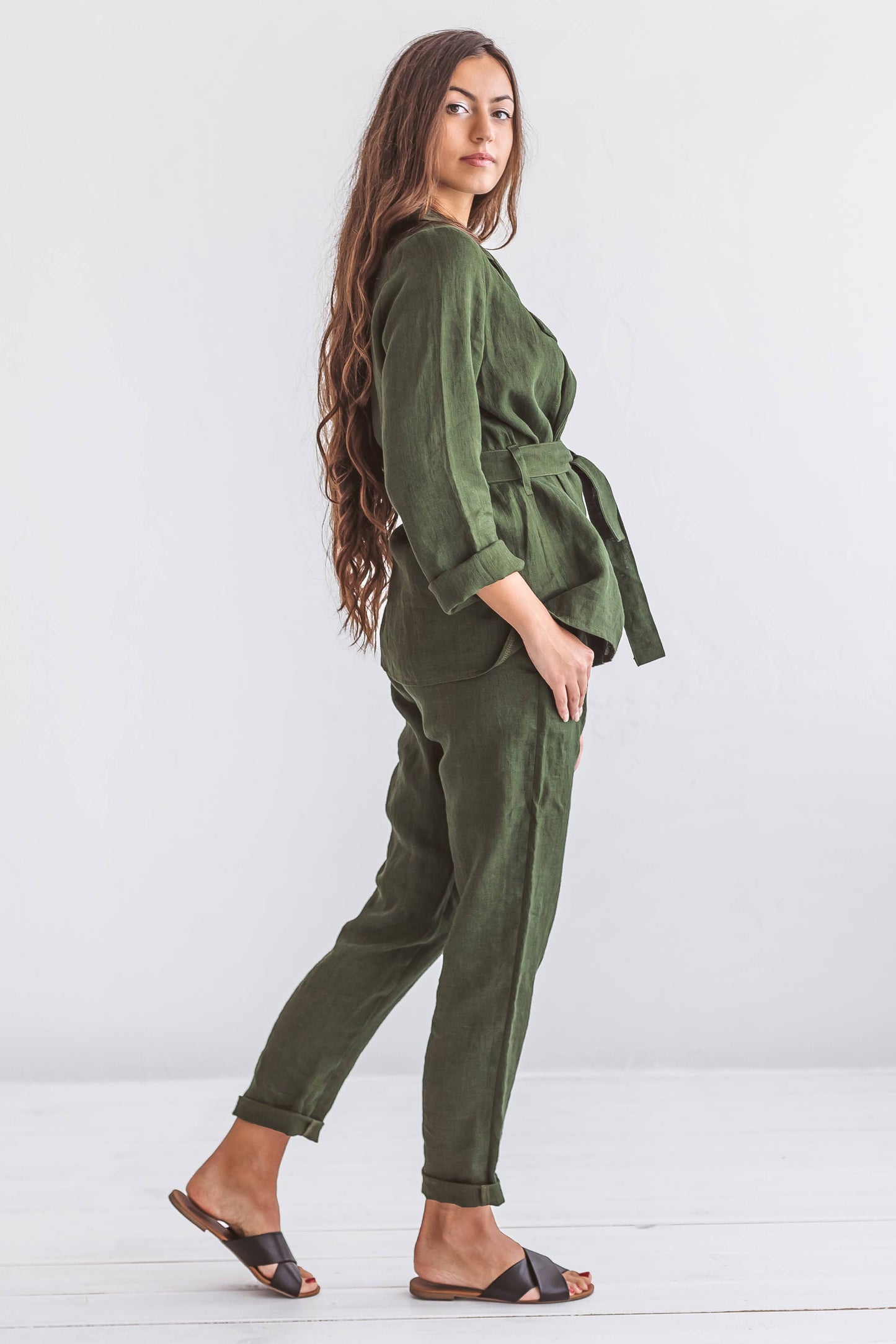 Forest green linen pants smiling pose in soft natural light studio, handmade linen pants slow fashion