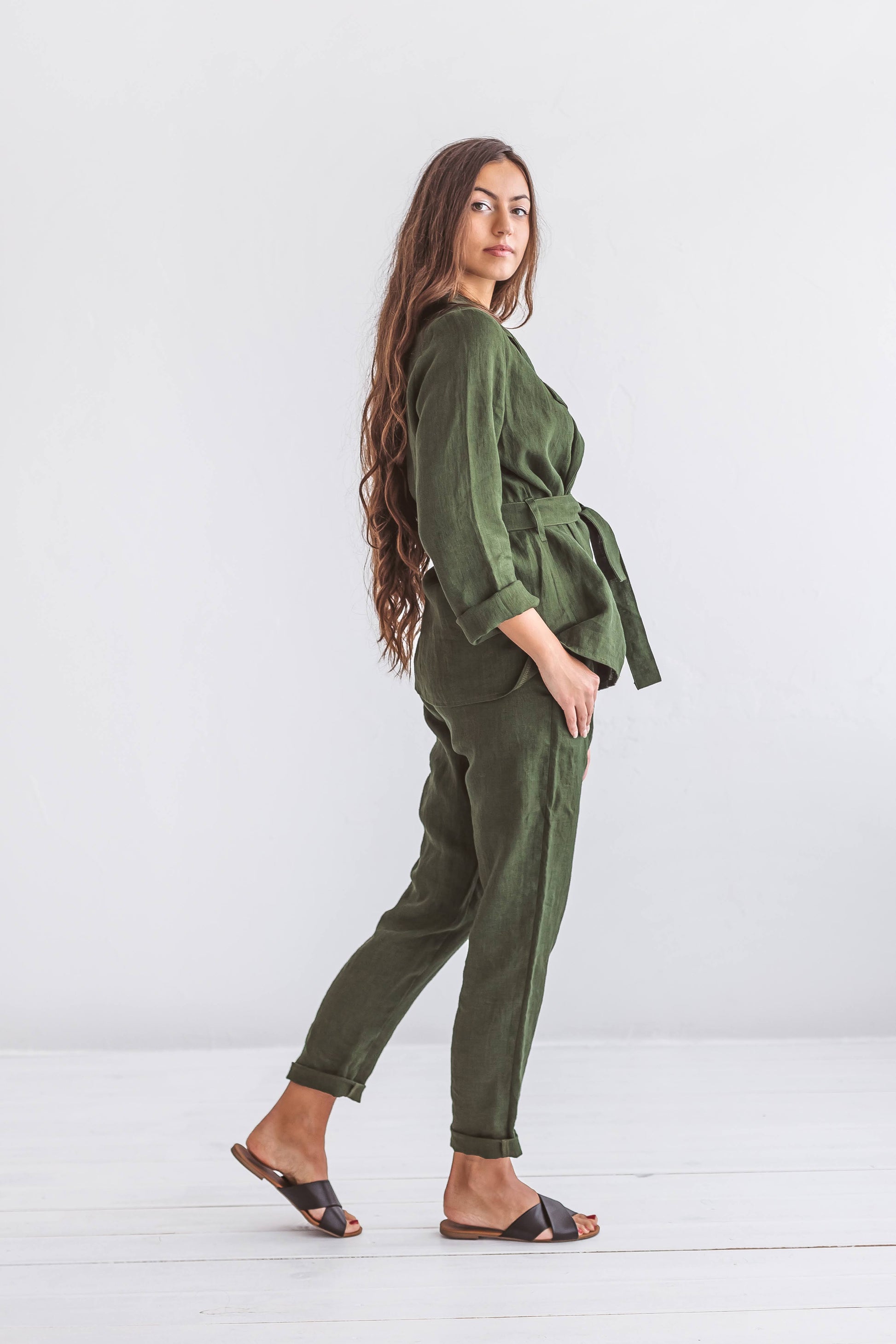 Forest green linen pants standing pose minimal natural aesthetic studio, handmade linen pants slow fashion