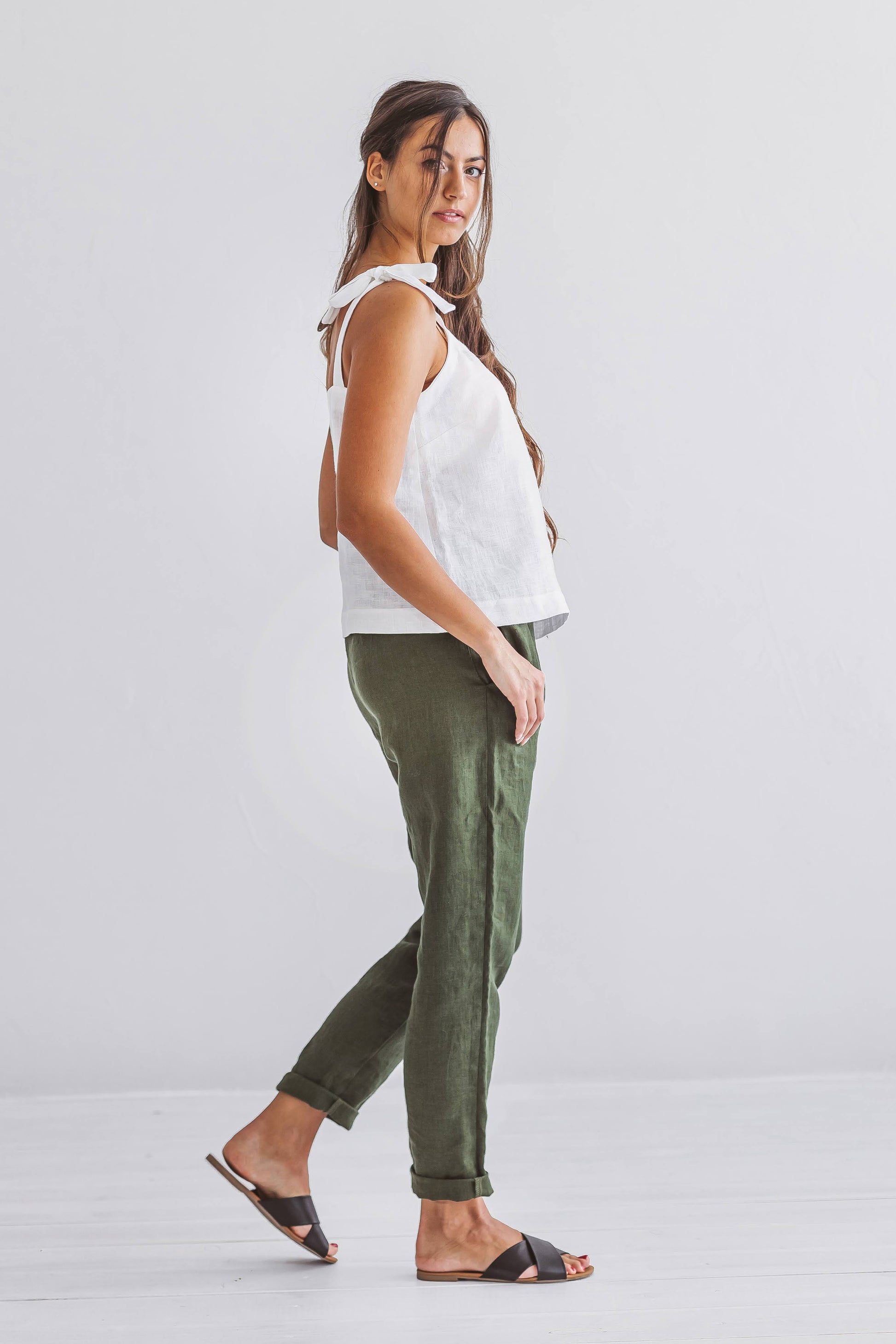 Forest green linen pants side view in natural light studio, handmade linen pants slow fashion