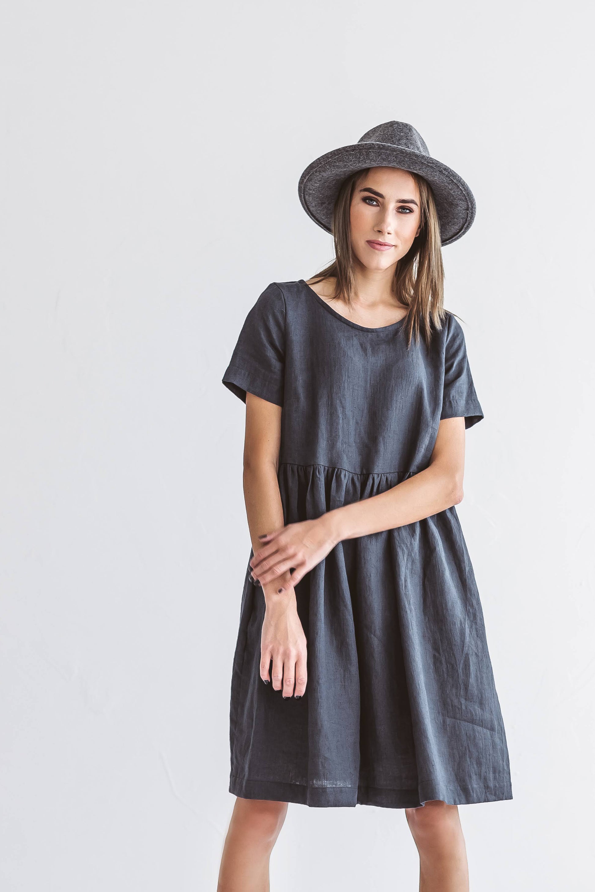 Graphite grey linen A-line dress standing relaxed pose smiling, handmade linen dress slow fashion