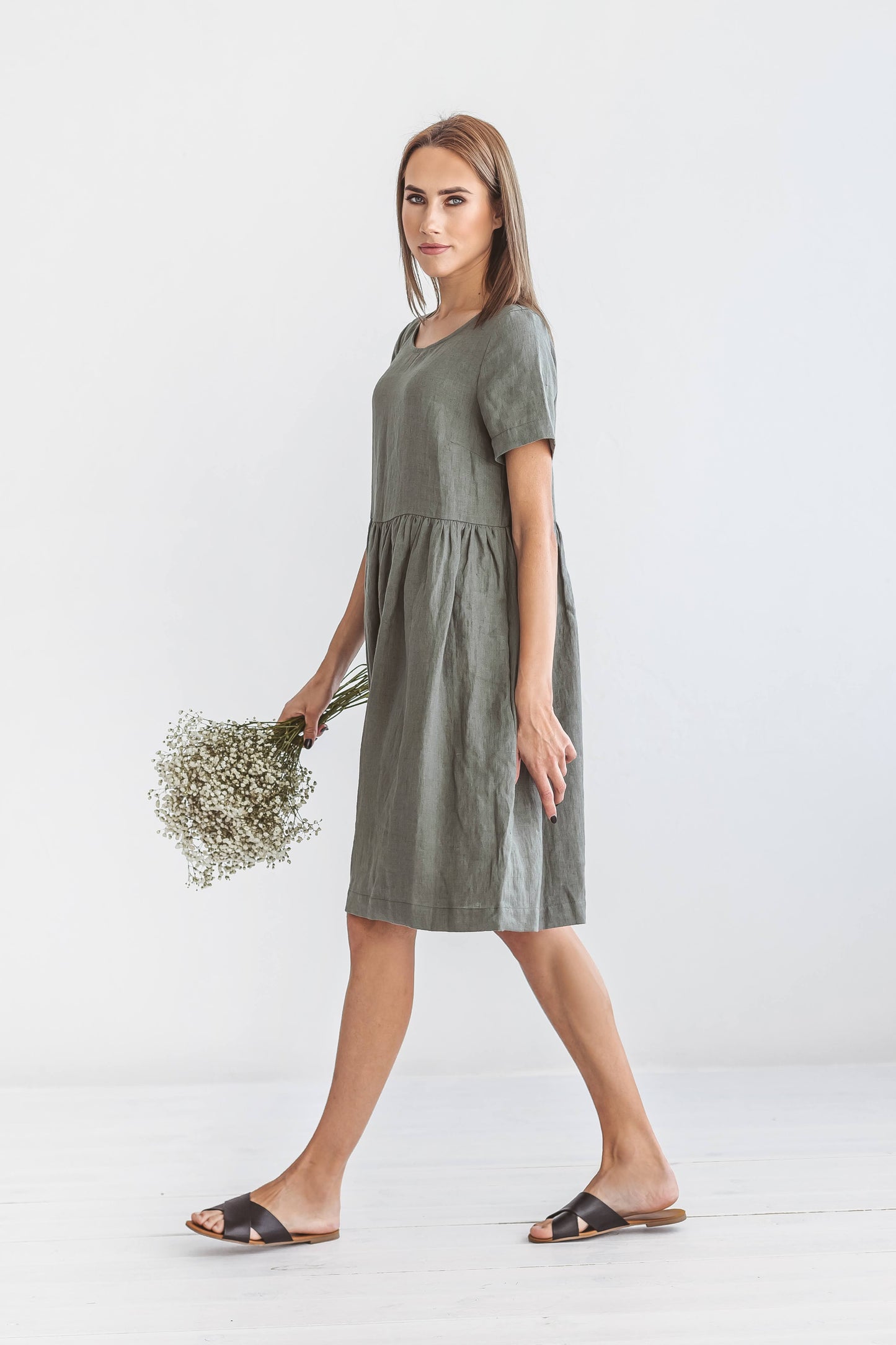Khaki linen A-line dress walking in relaxed pose showing soft drape, handmade linen dress slow fashion