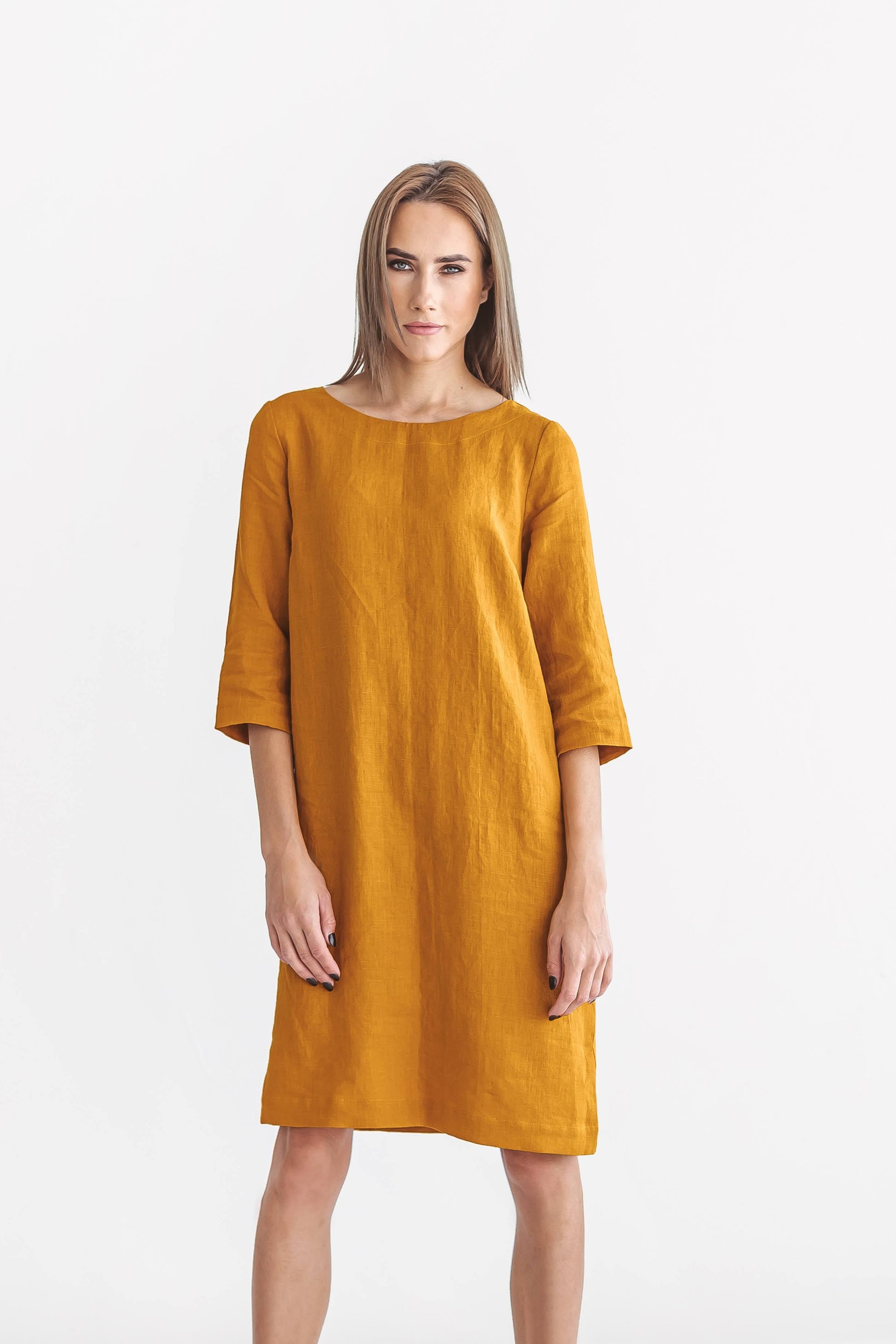 Mustard linen dress front view standing against minimal background, handmade linen dress slow fashion