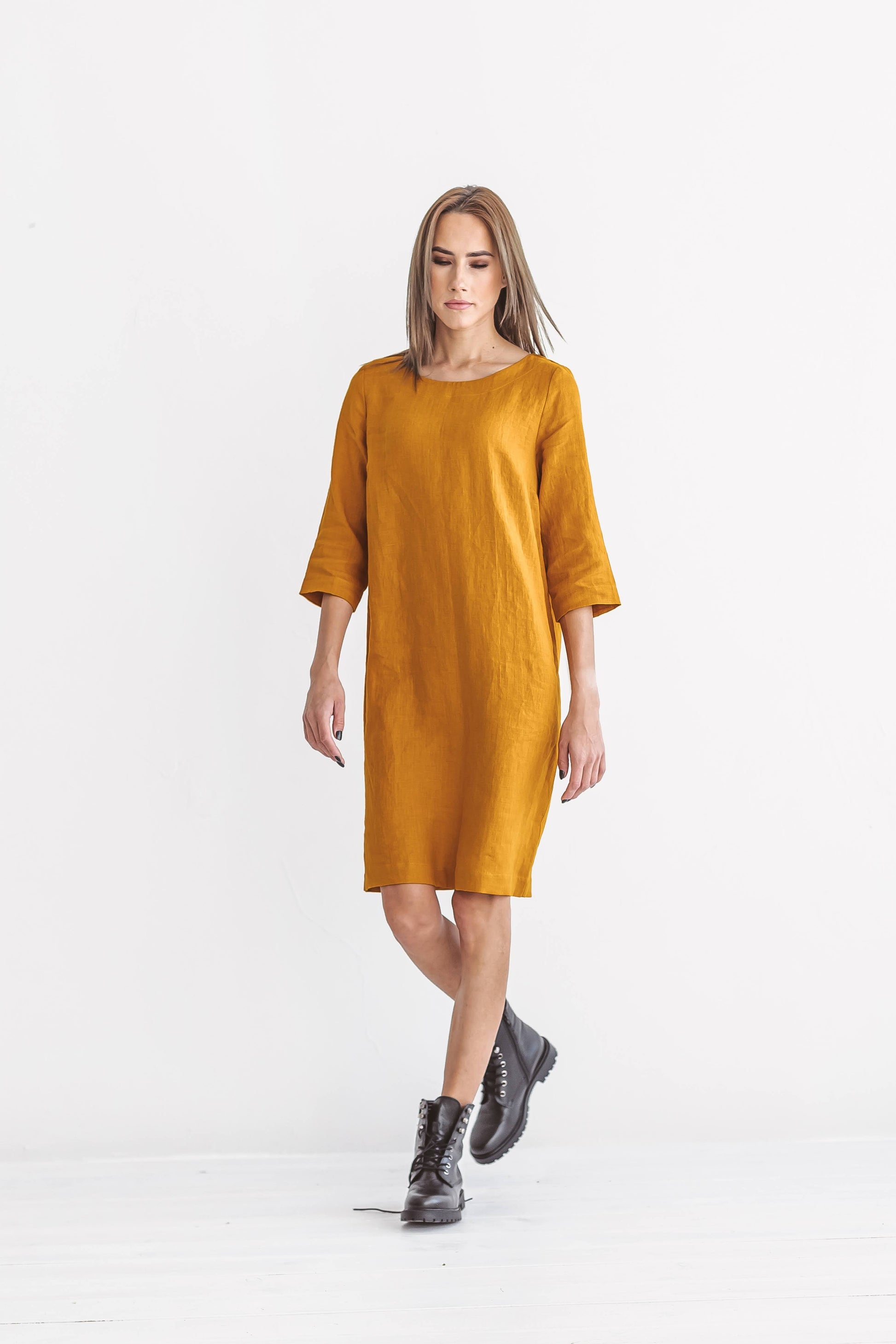 Mustard linen dress walking front view against minimal background, handmade linen dress slow fashion