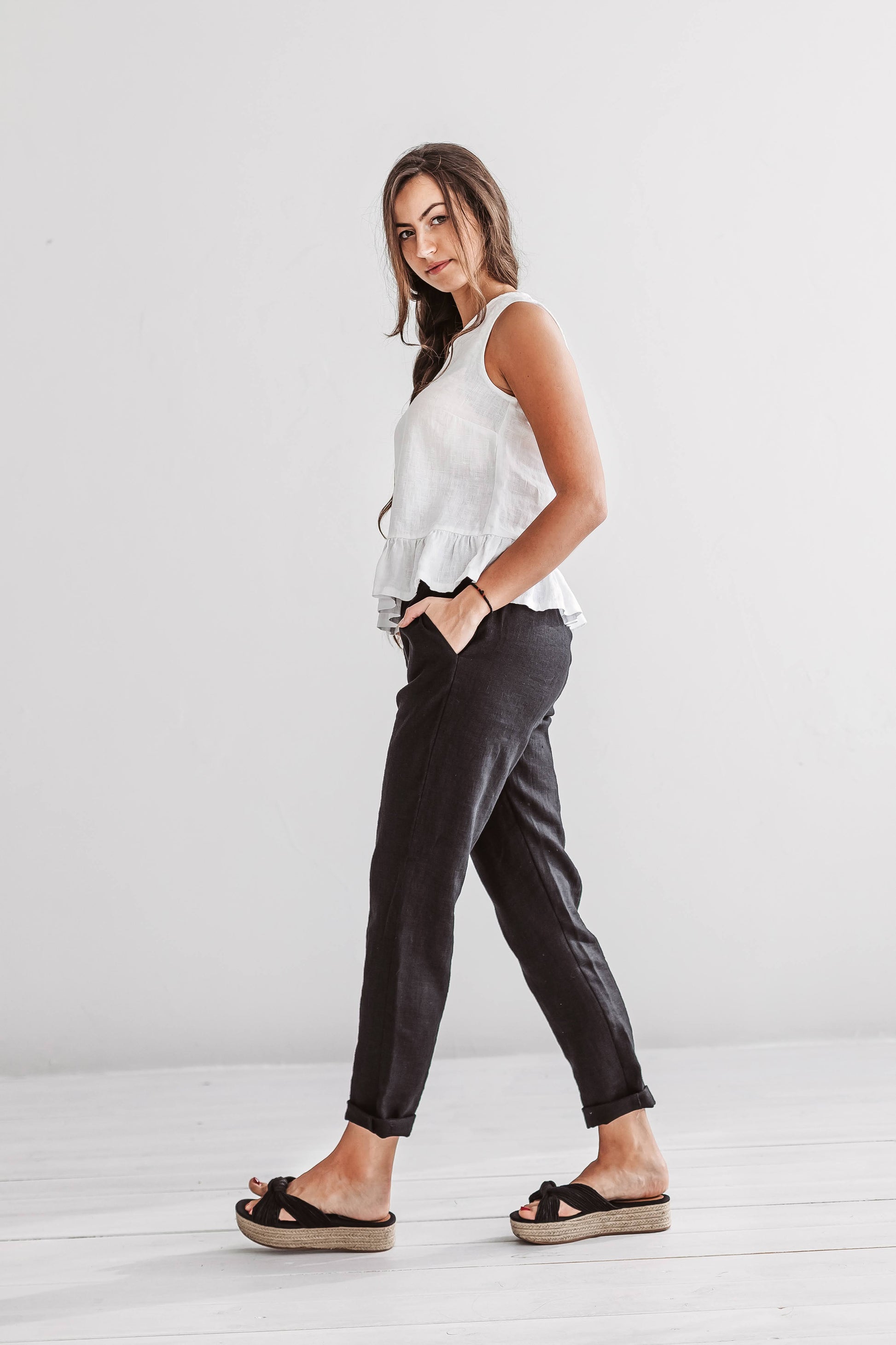 White linen top full-body view styled with trousers showing sleeveless cut, handmade linen top slow fashion