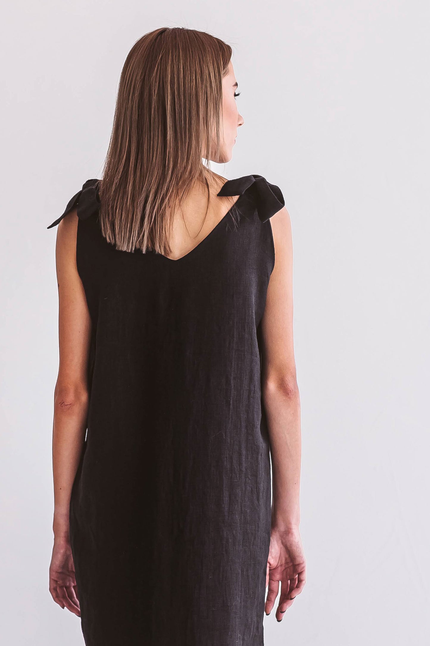 Black linen dress back view standing naturally showing relaxed drape, handmade linen dress slow fashion