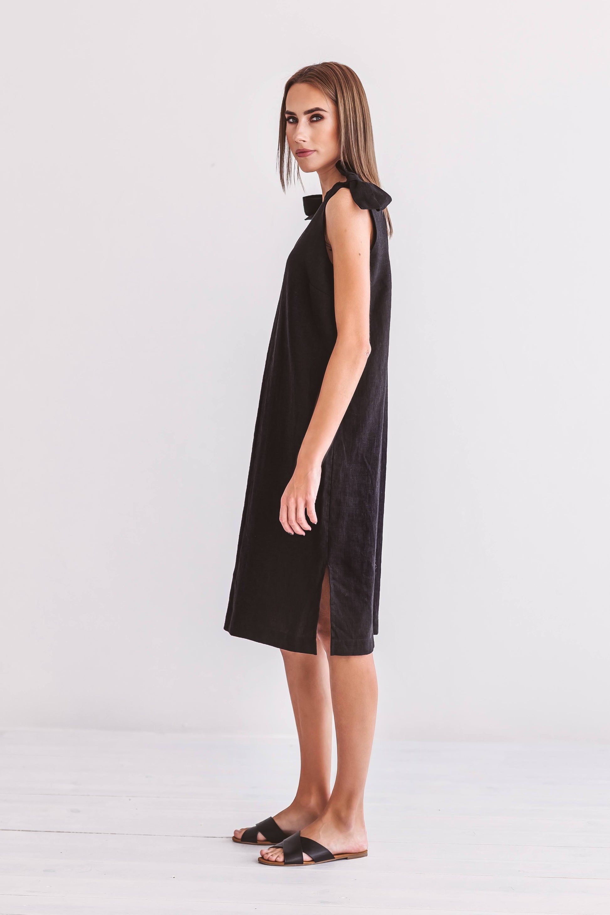 Black linen dress side view relaxed standing pose showing loose fit, handmade linen dress slow fashion