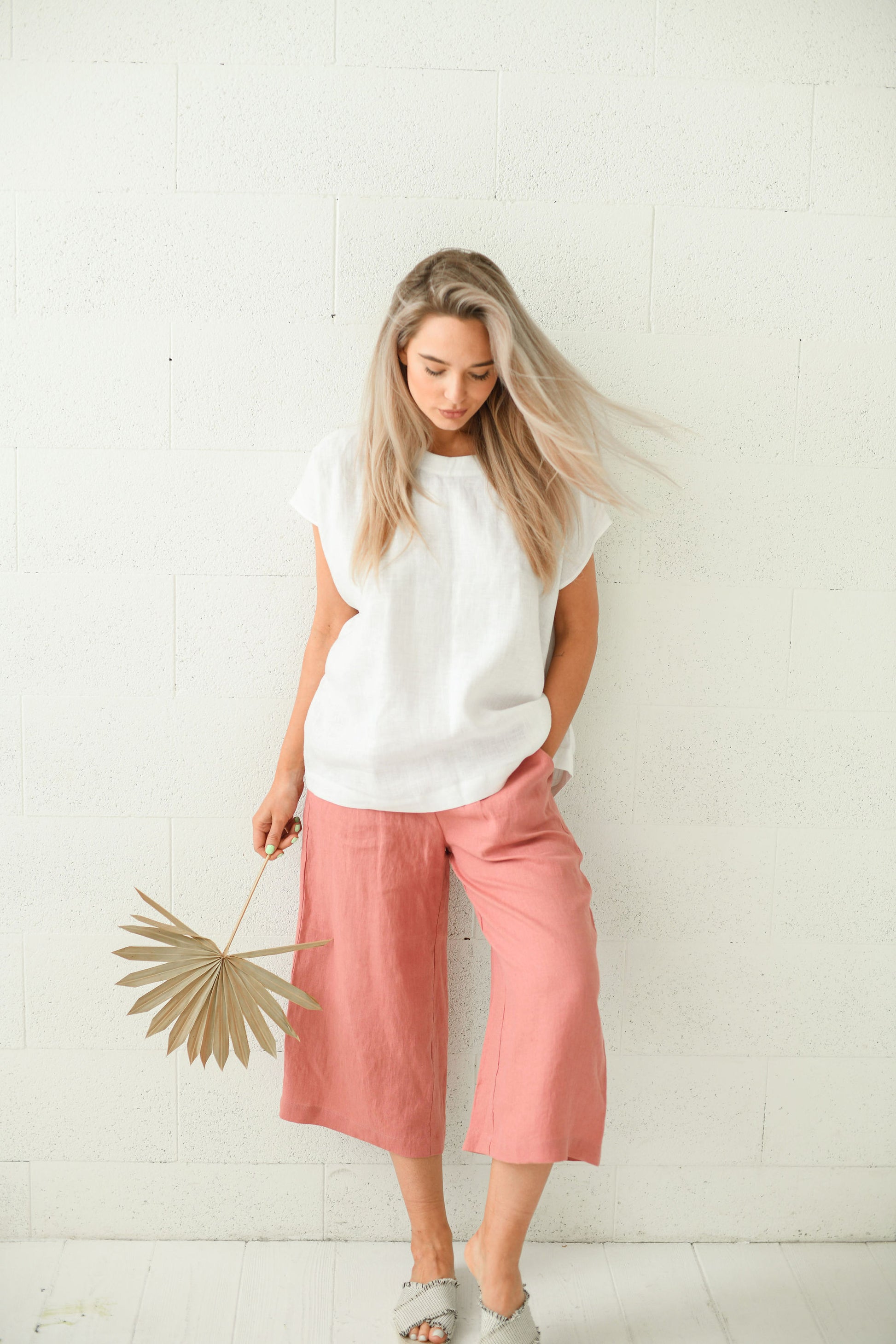 Salmon linen pants standing front-facing looking down showing comfortable fit, handmade linen pants slow fashion