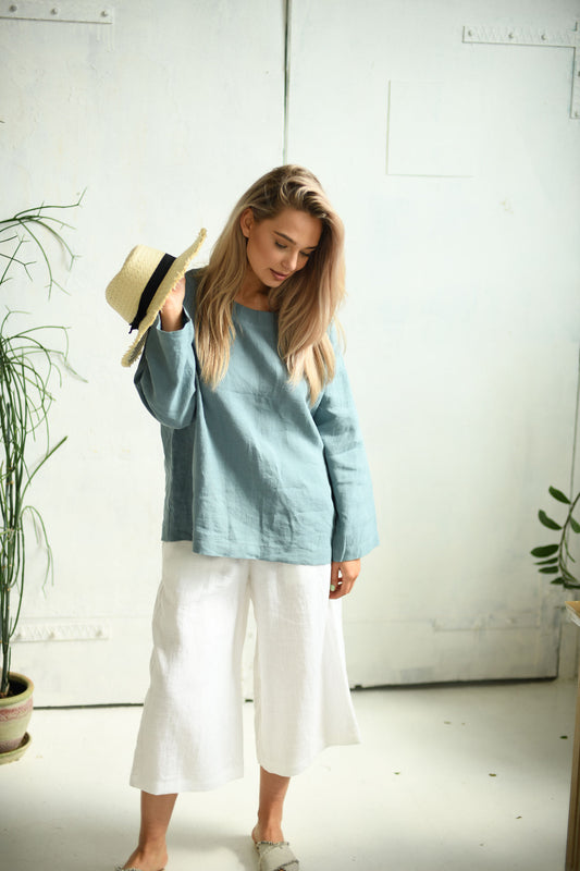 White linen pants relaxed front view looking down with hat showing drape, handmade linen pants slow fashion